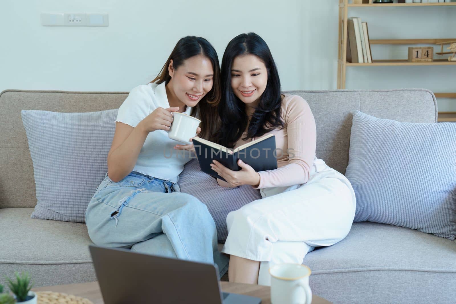 lgbtq, LGBT concept, homosexuality, portrait of two Asian women posing happy together and showing love for each other while having coffee at the dining table.