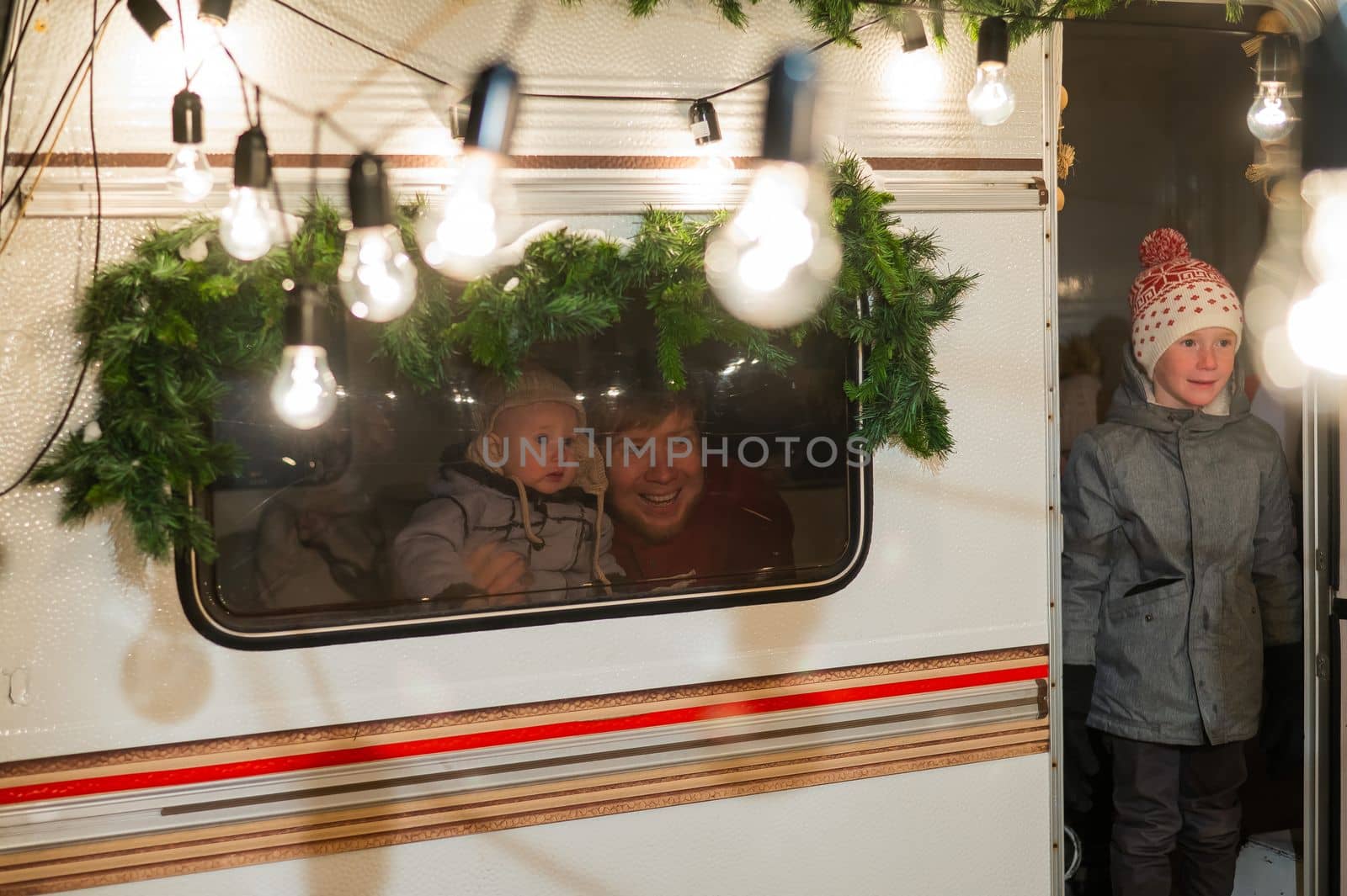 Father and two sons celebrate Christmas in a van