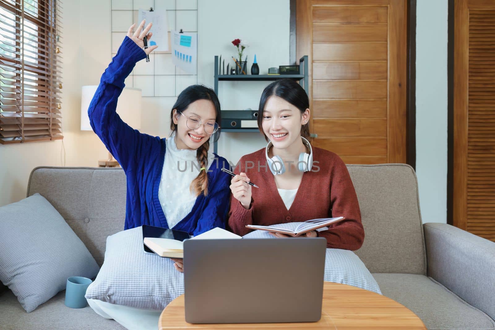 lgbtq, lgbt concept, homosexuality, portrait of two asian women posing happy together and loving each other while playing computer laptop with notebook for learning online by Manastrong