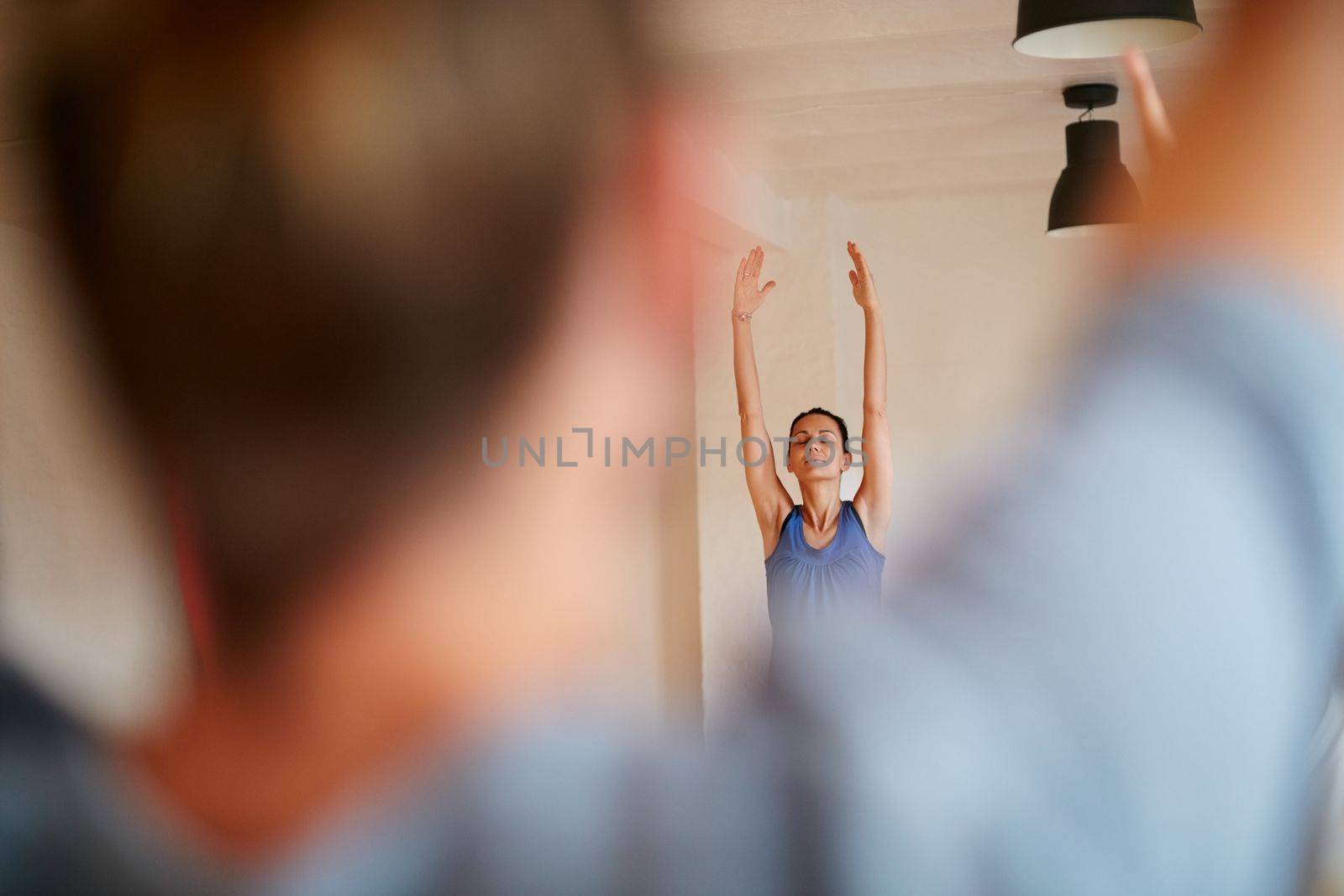 Be aware of the beauty of the mind-body connection. people practising yoga in a studio