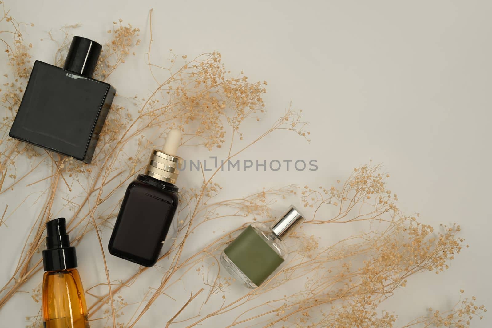 Cosmetic products set and dried flowers on white background . Skincare beauty products design and branding.