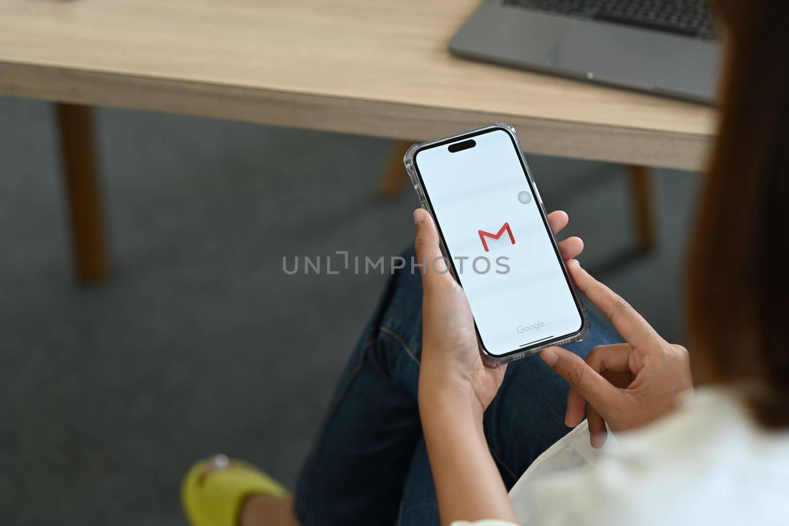 Chiang Mai, Thailand - Oct 08,2022: Woman iPhone 14 Pro Max with Gmail app on screen. Gmail is a free email service from Google by prathanchorruangsak