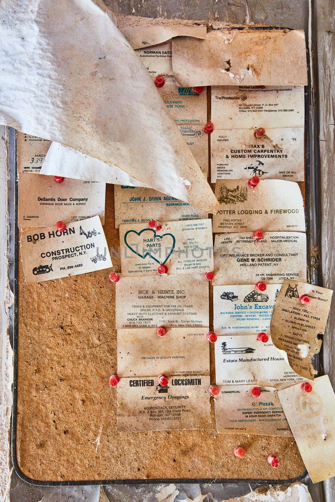 Image of Abandoned cork board covered with old business cards pinned