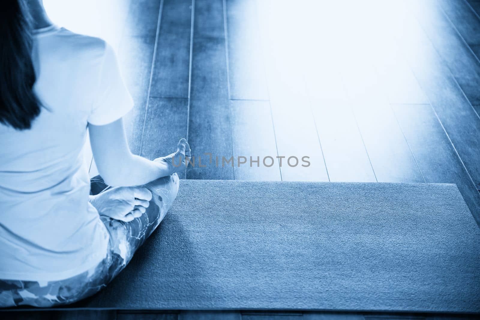 Young woman meditating sitting in lotus position by Mariakray