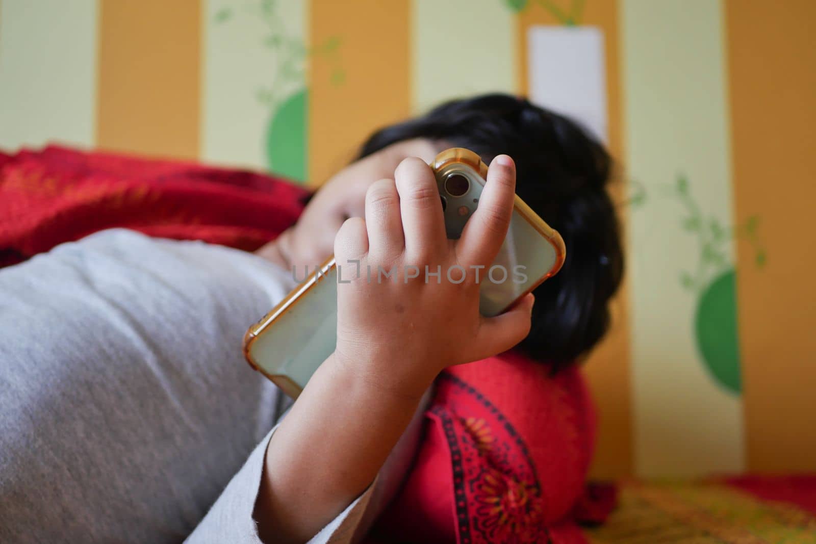 child using smart phone on bed ,