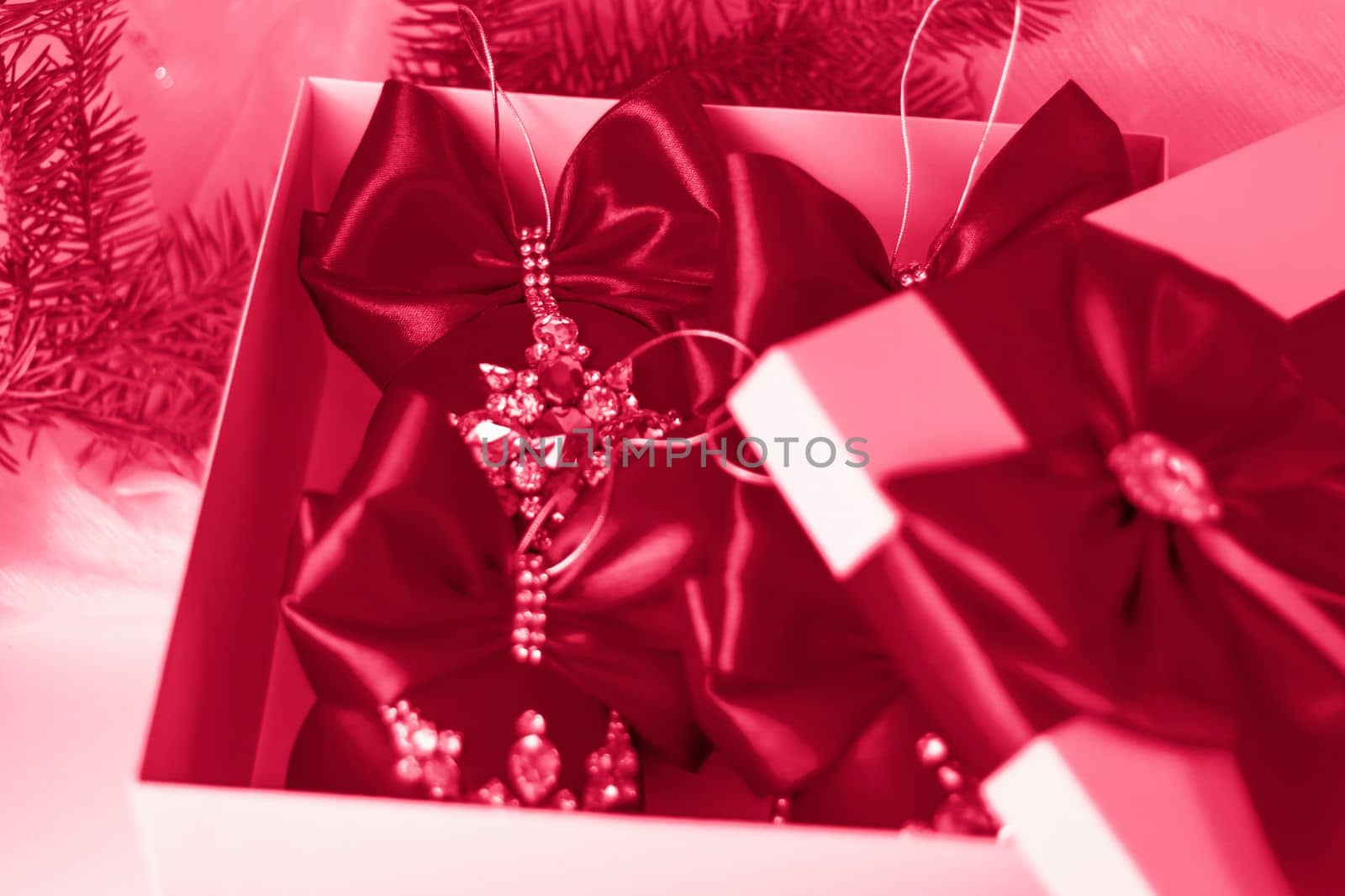 A Christmas gift decorated with a beautiful bow on a light background with a fir twig. Gifts, joy, surprise. Selective focus. the concept of Christmas and New Year by Alina_Lebed