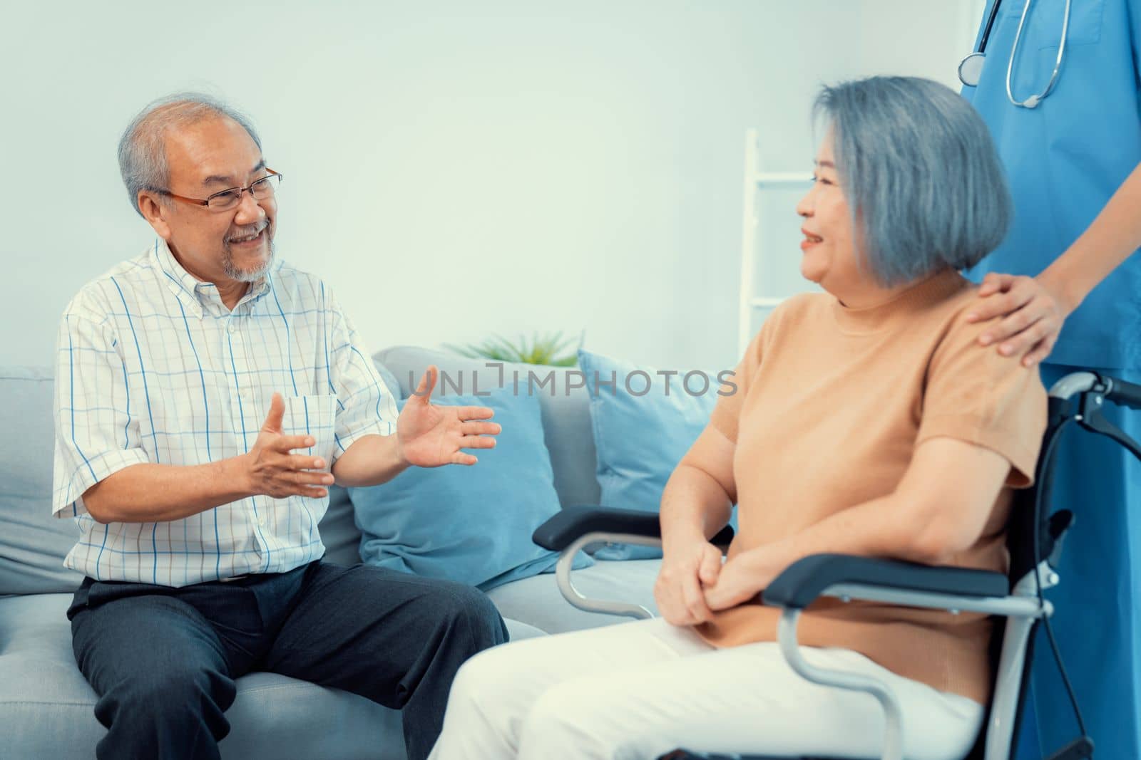 A contented senior couple and their in-home nurse. Elderly female in wheelchair with her young caregiver.