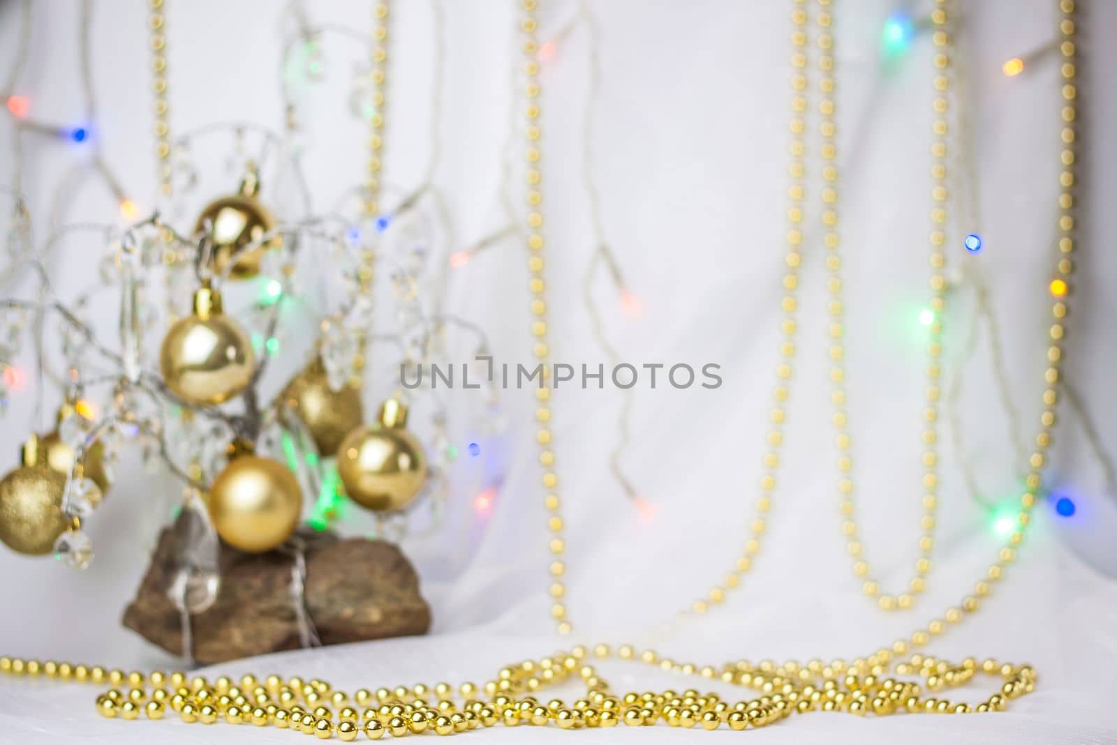 Christmas background with a Christmas tree on which small golden balls hang. Selective focus, a picture for the background. the concept of Christmas and New Year. by Alina_Lebed