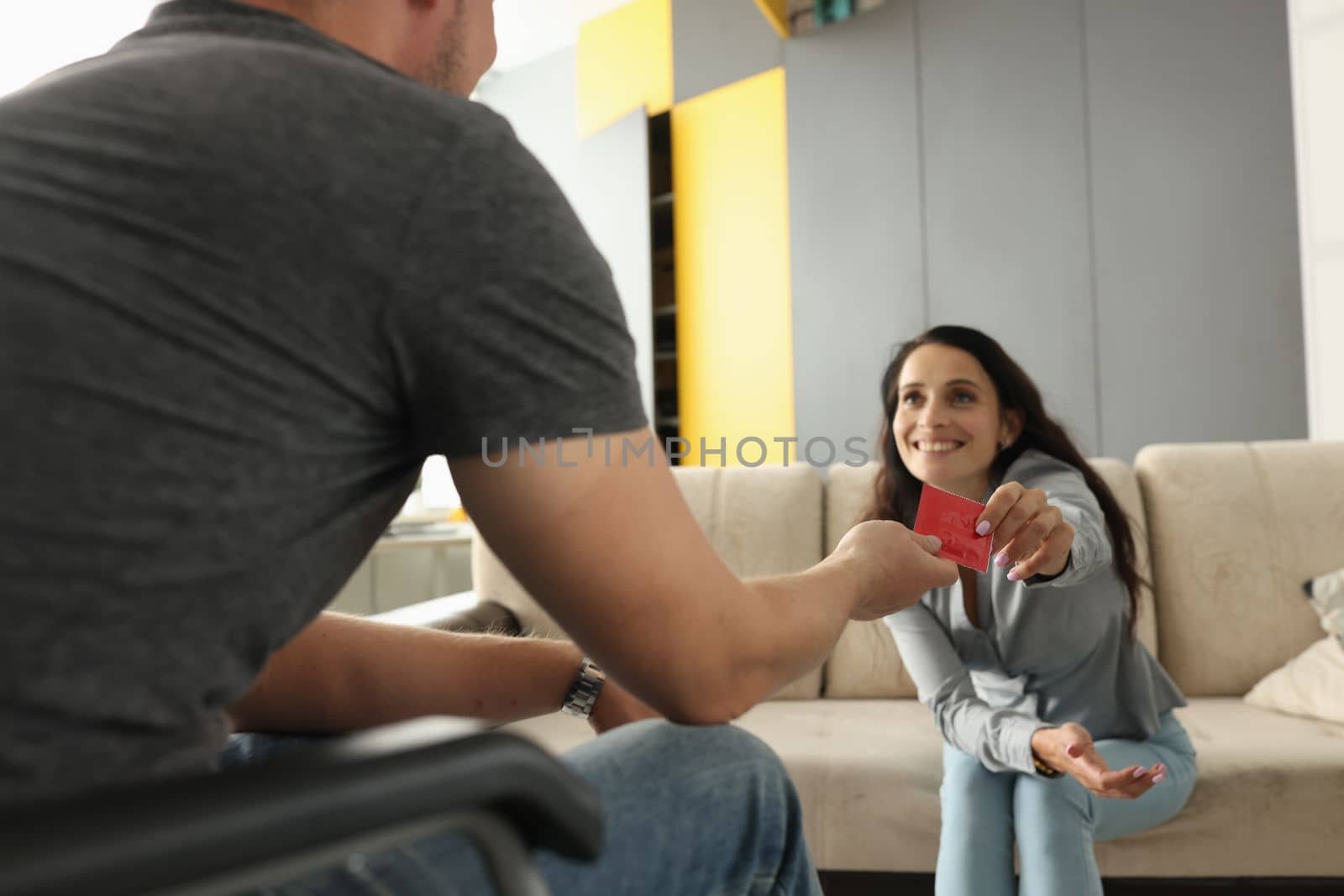 Man hands condom package to smiling woman. Safe healthy sex concept