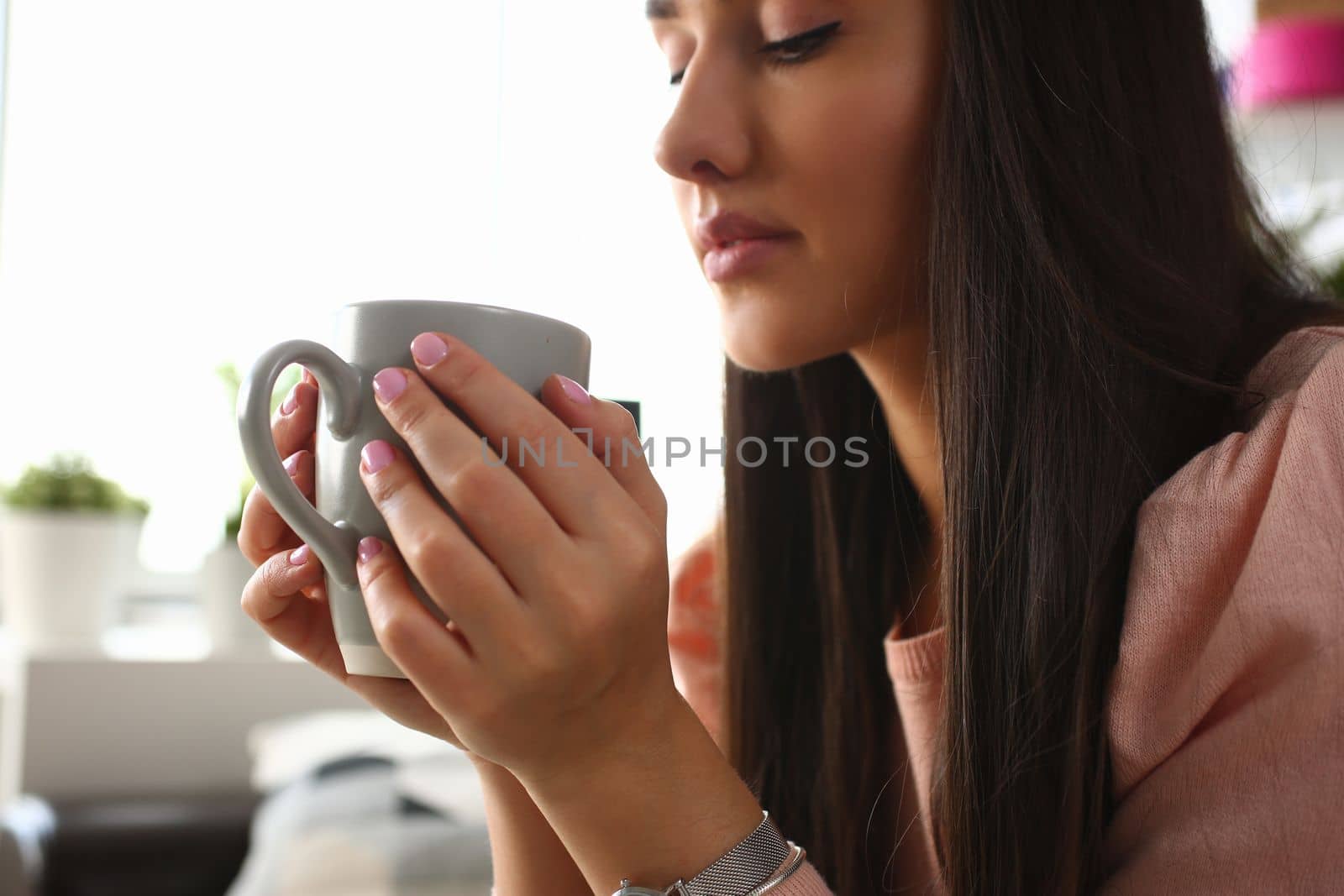 Sad gloomy young woman holding cup at home. Bad mood apathy and depression concept