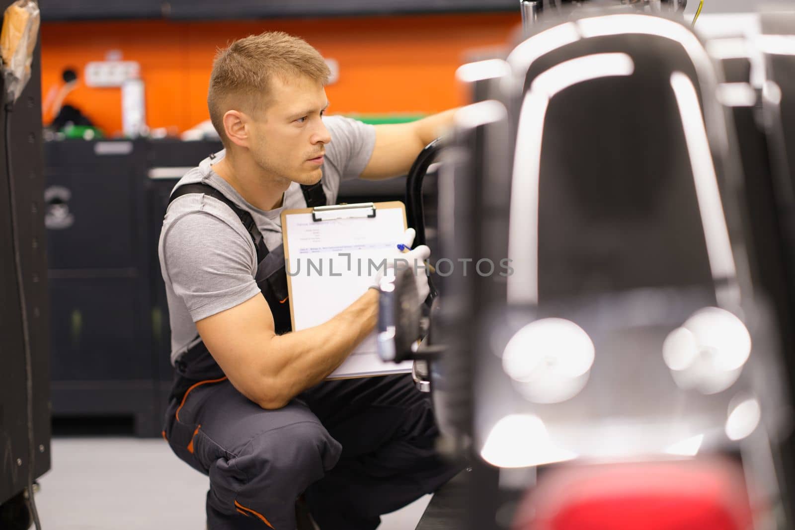 Male mechanic inspects motorcycle in workshop. Motorcycle service quality assurance concept