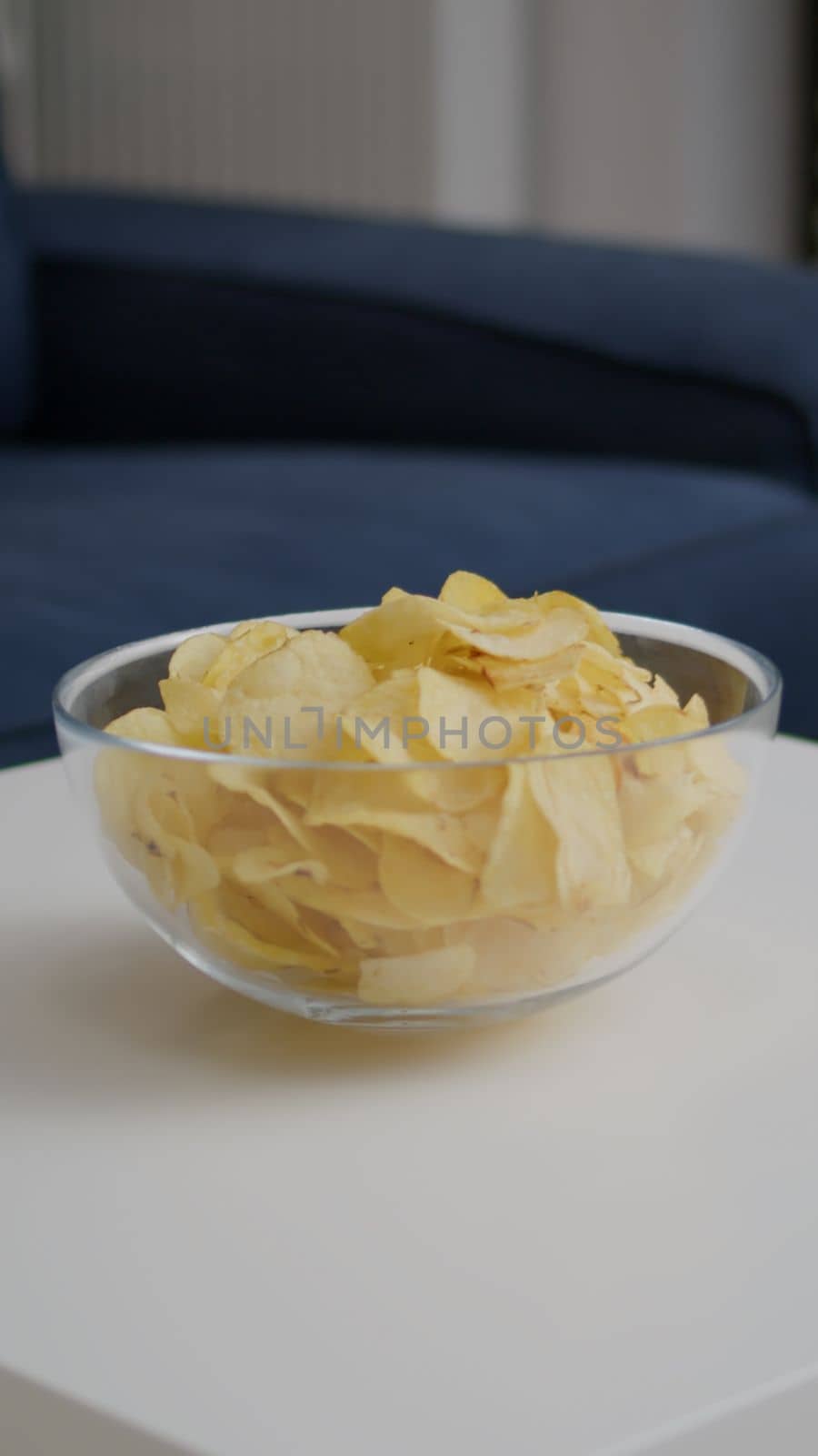 Closeup of junk fried potato bowl put on woden table in empty party room with nobody in it. Apartament is ready for friends gathering celebrating wekeend birthday party late at night