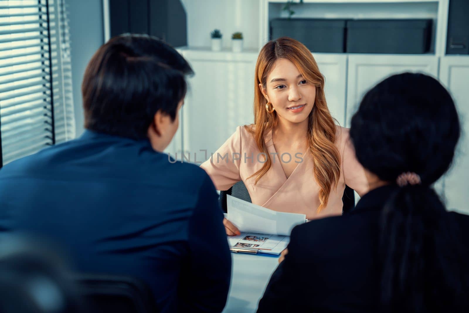 A young female asian candidate tries to impress her interviewer by being competent. International company, multicultural environment in workplace.