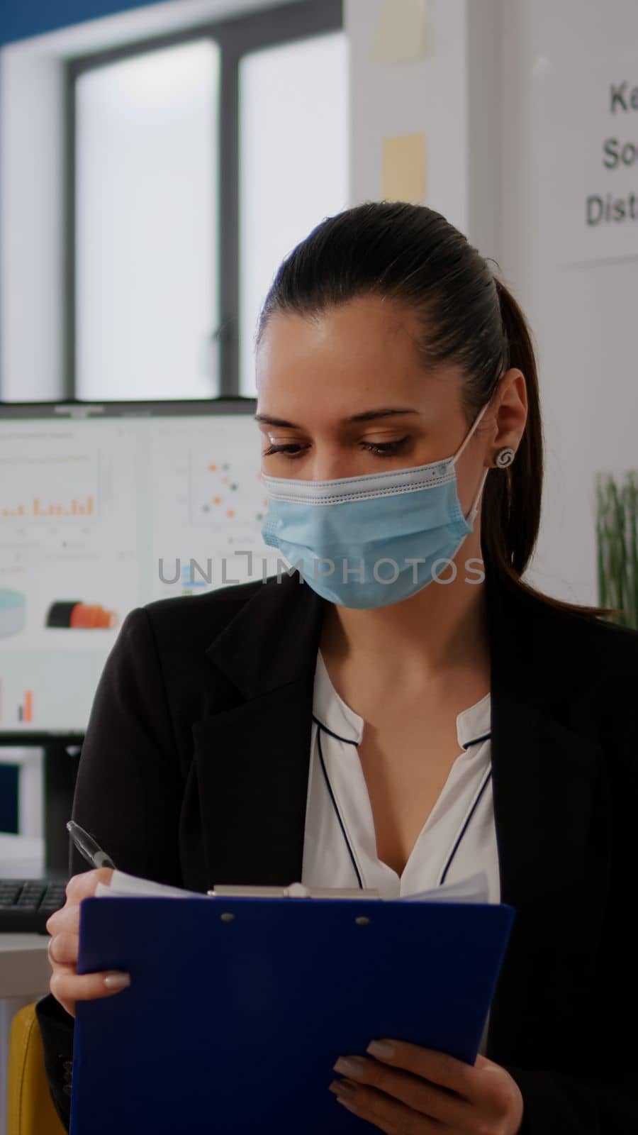 Pov of business woman with medical face mask working at communication project with team during online video conference. Entrepreneur on web internet video call in new normal corporate space