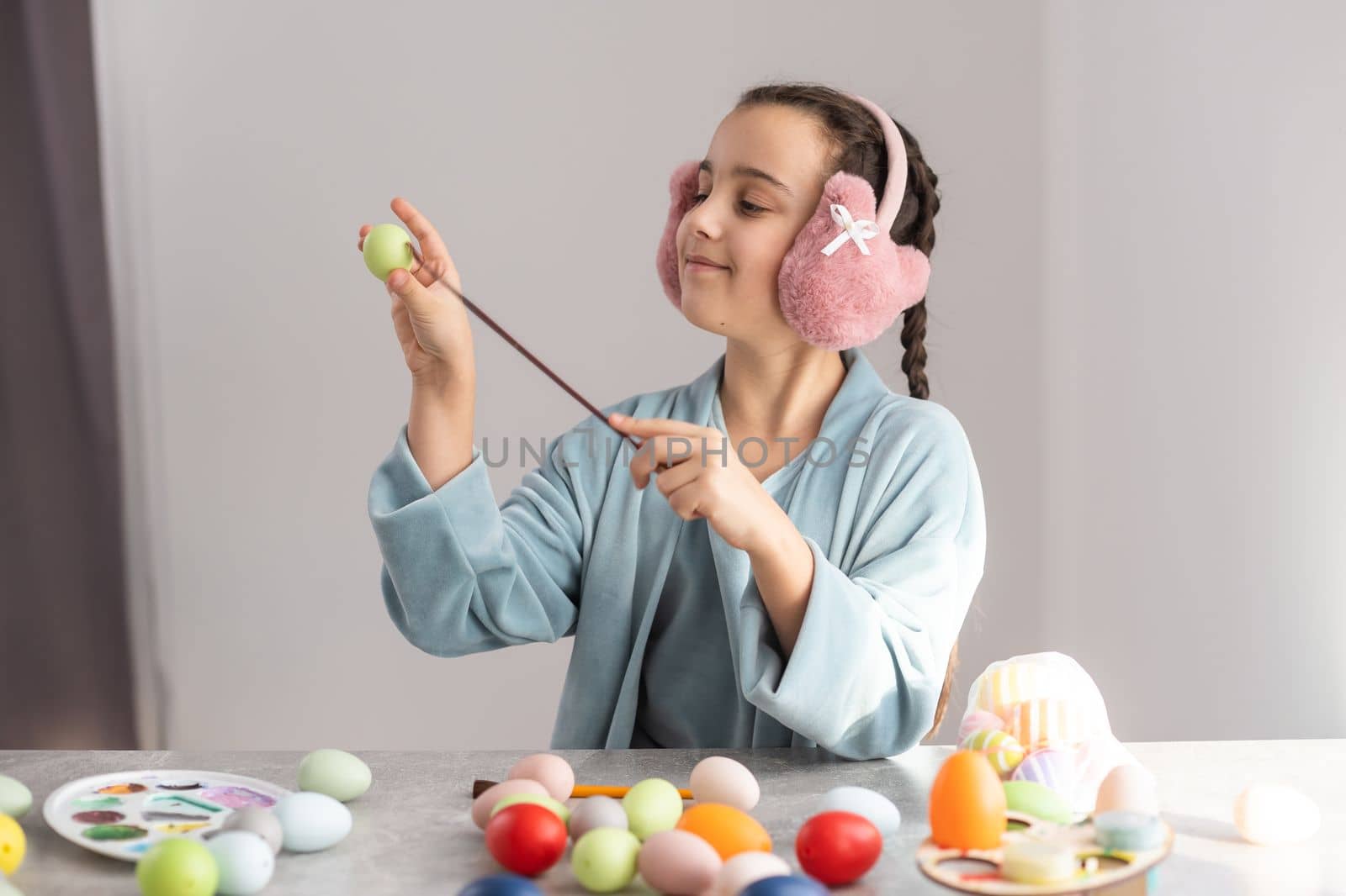 easter holiday celebration, cute girl, happy small child near colorful eggs, pencils.