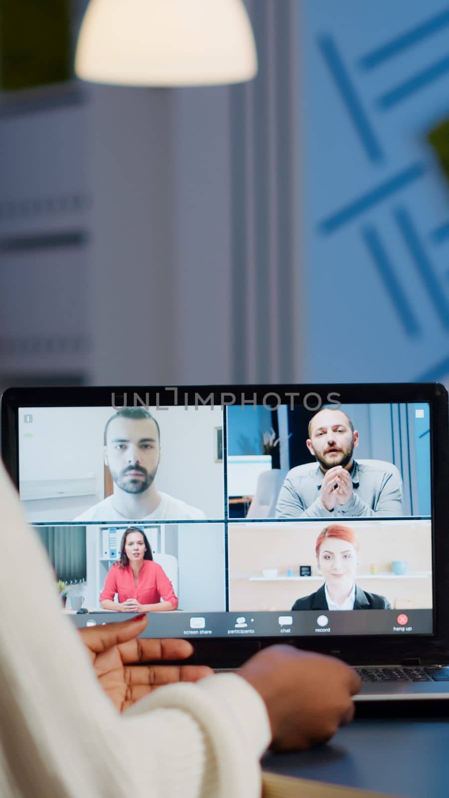 Back view of black business woman talking on video call with team by DCStudio