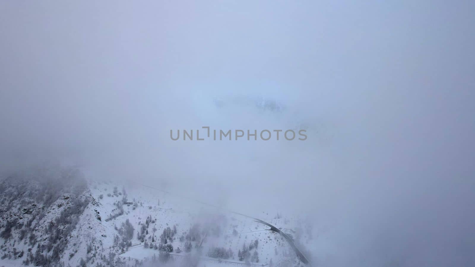 Snowy mountains with coniferous trees in clouds by Passcal