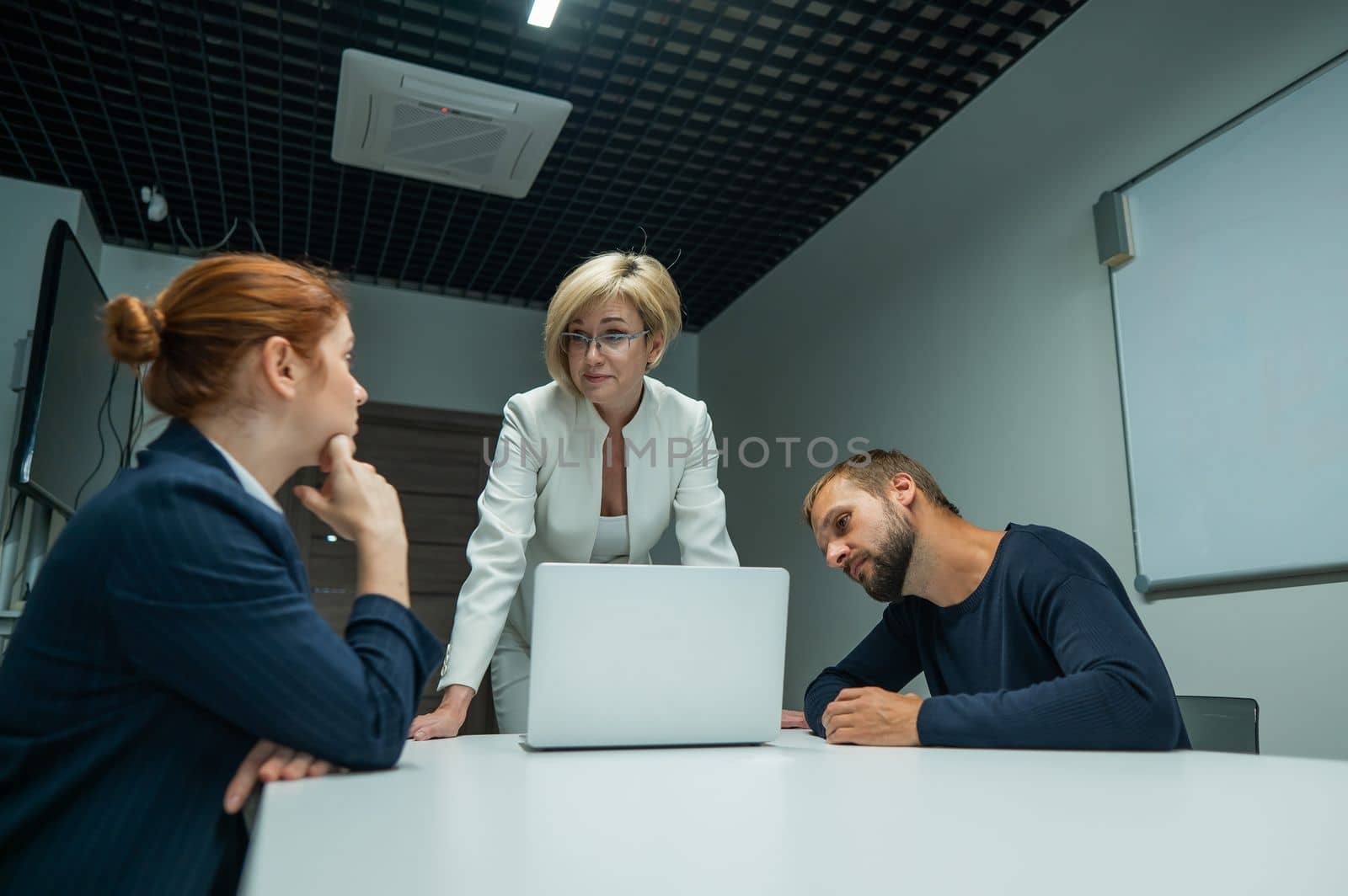 Blond, red-haired woman and bearded man in suits in the office. Business people are negotiating in the conference room. by mrwed54