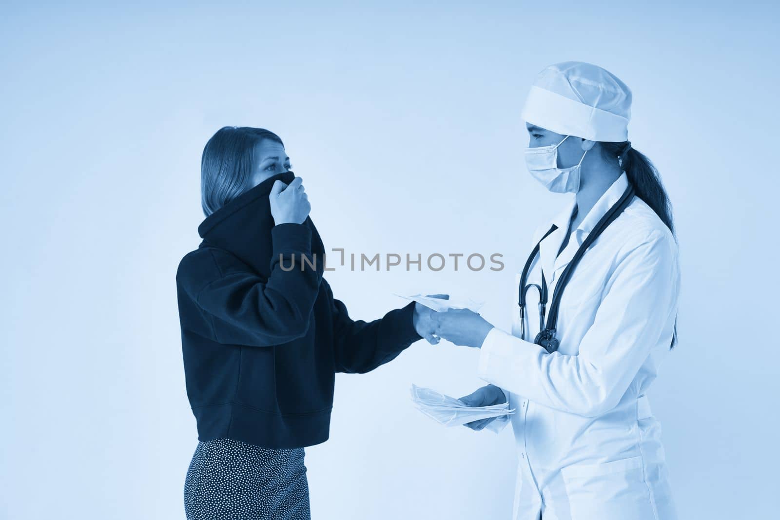 Doctor giving a patient protective face mask to protect from virus infection, coronavirus concept by Mariakray