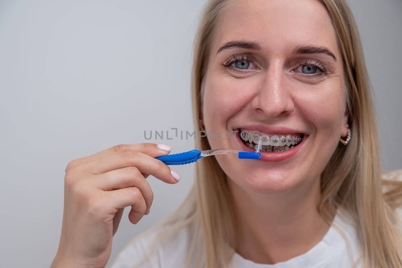 Caucasian woman cleaning her teeth with braces using a brush