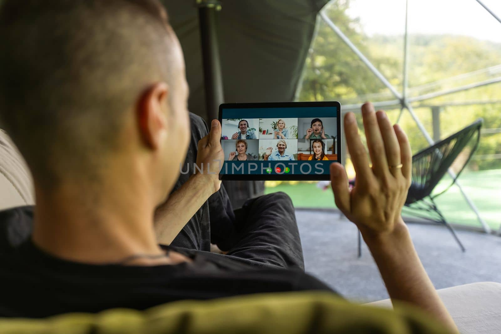 male hand holding tablet having video chat with colleagues. man watch online business webinar on digital tablet by Andelov13