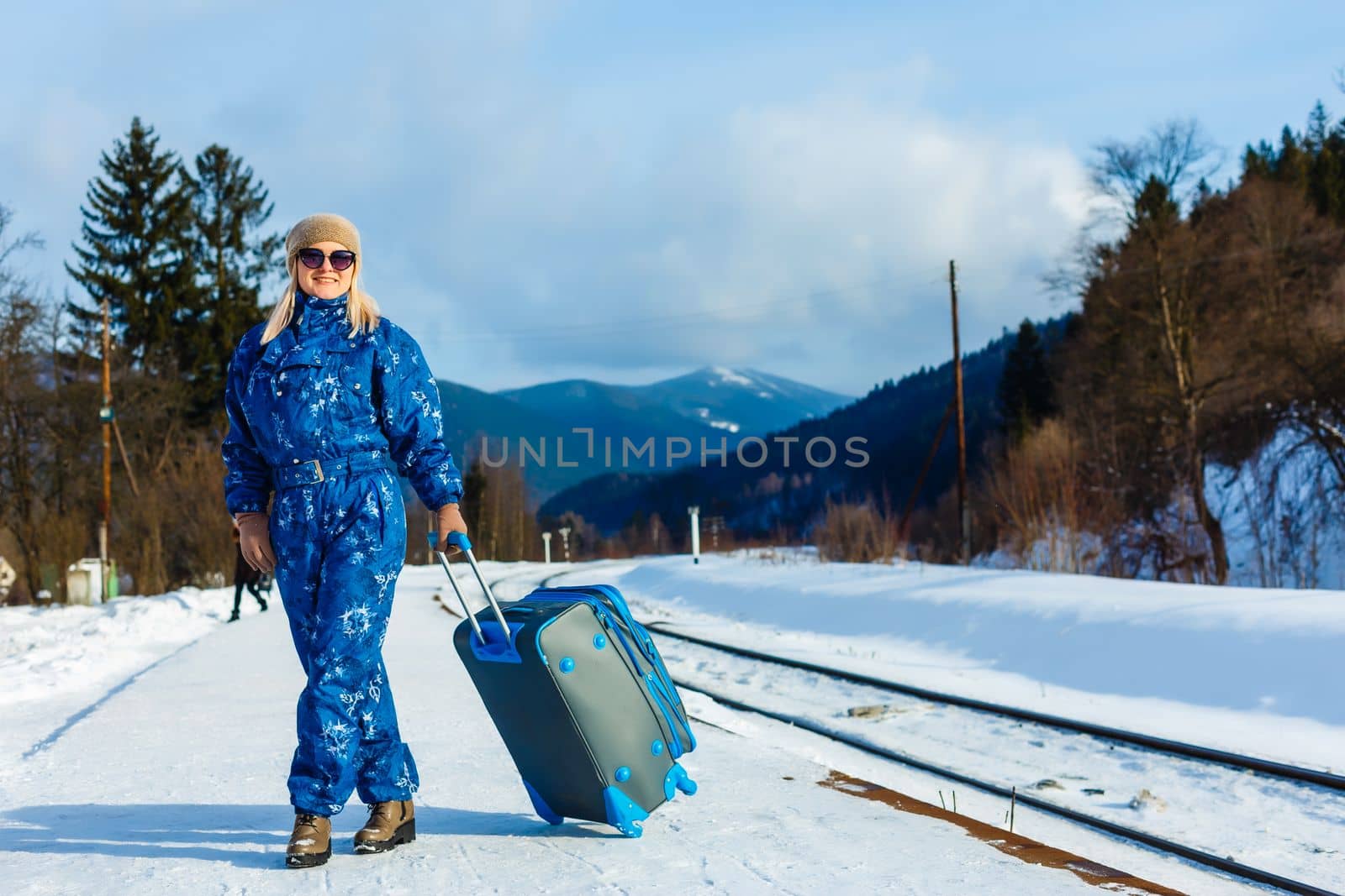 woman in ski suits stands near the railway by Andelov13
