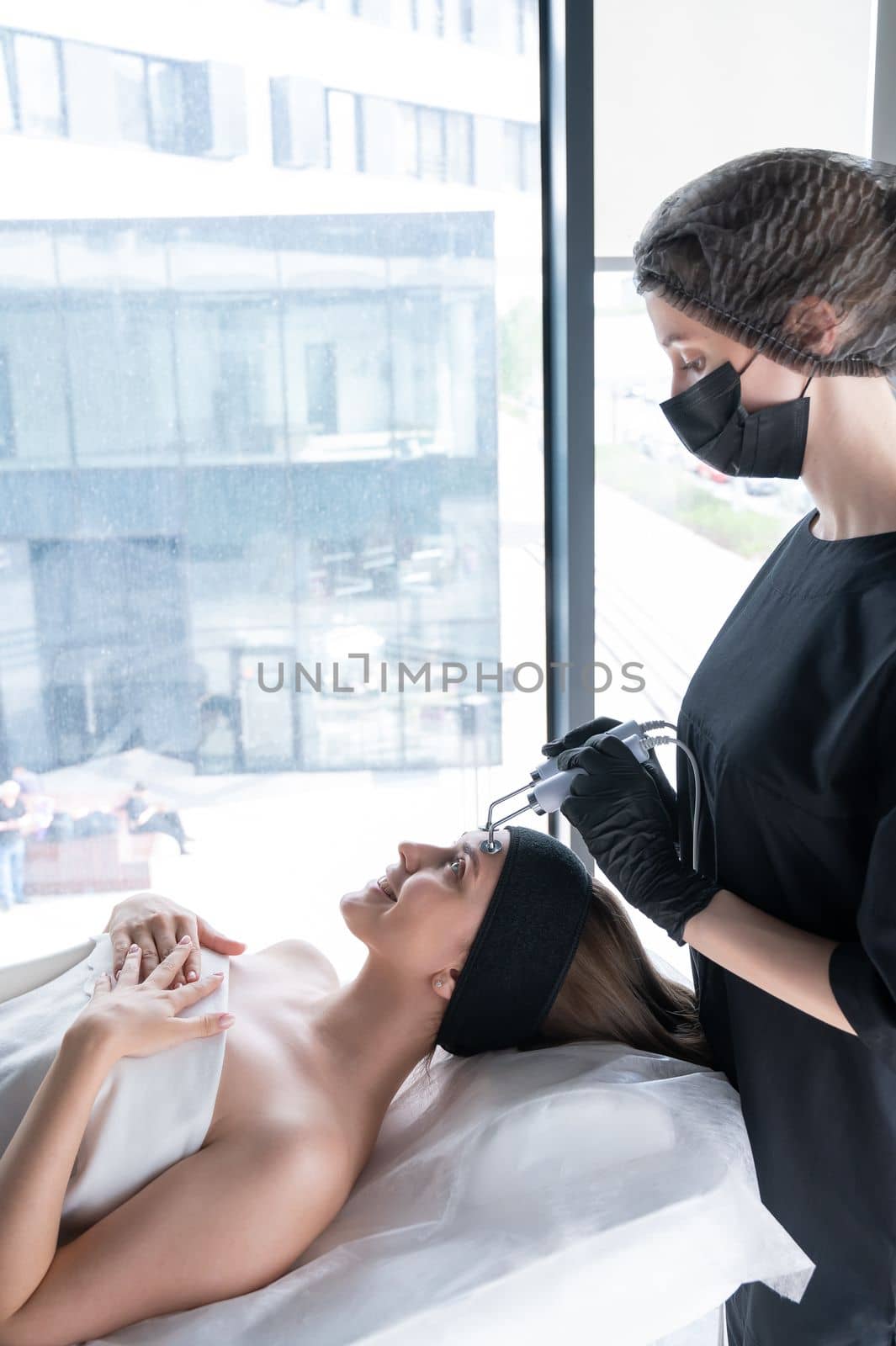 Young caucasian woman on microcurrent therapy procedure. Beautician's office