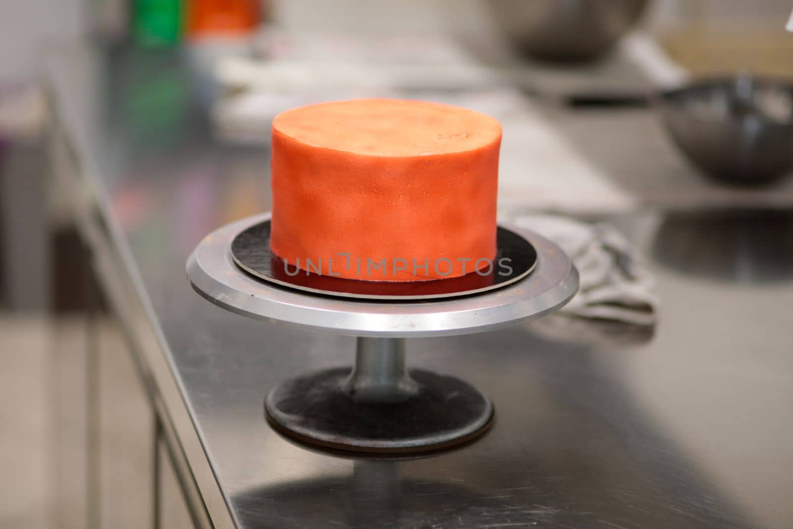 cook preparing a red frosted cake using air bush