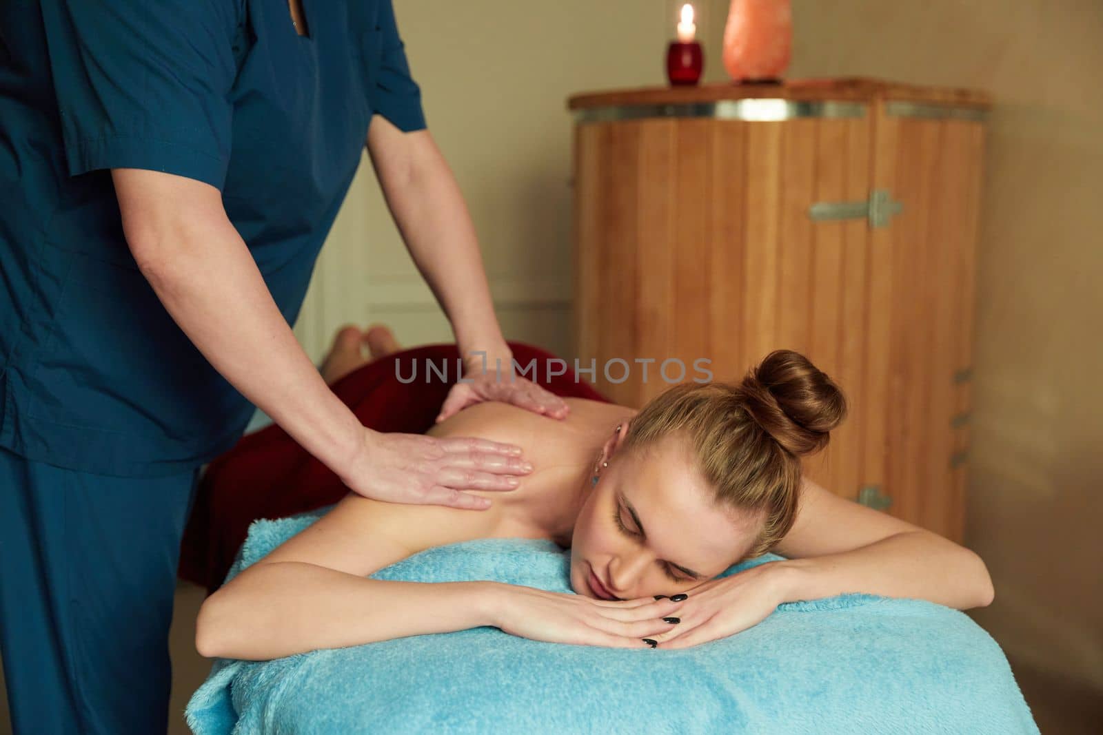 Young woman receiving massage in spa salon by Mariakray
