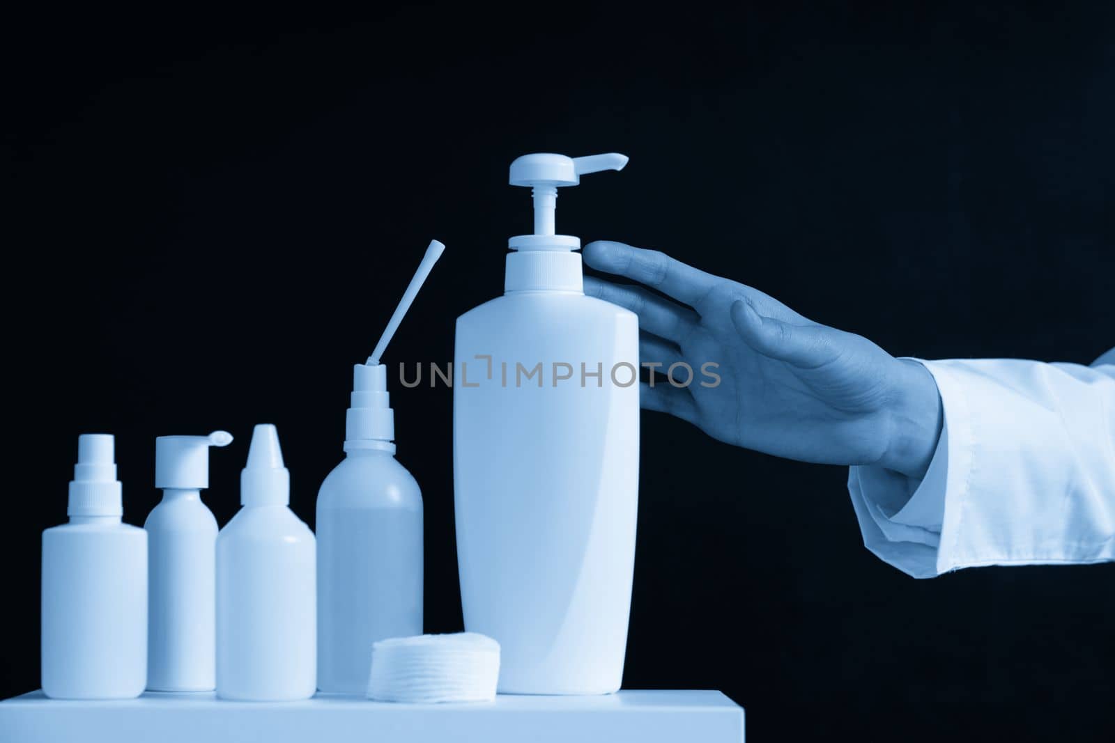Bottles of hand sanitizers and liquid soap on a black background