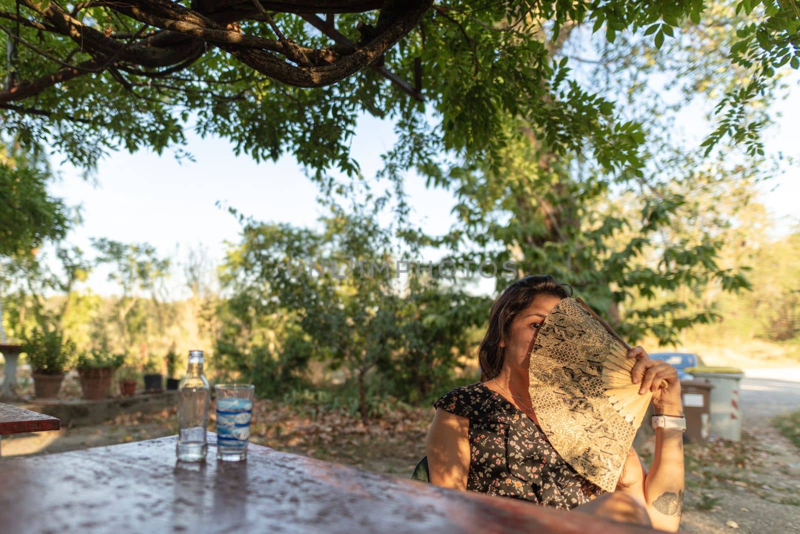 young adult latino woman drinking beer outdoors