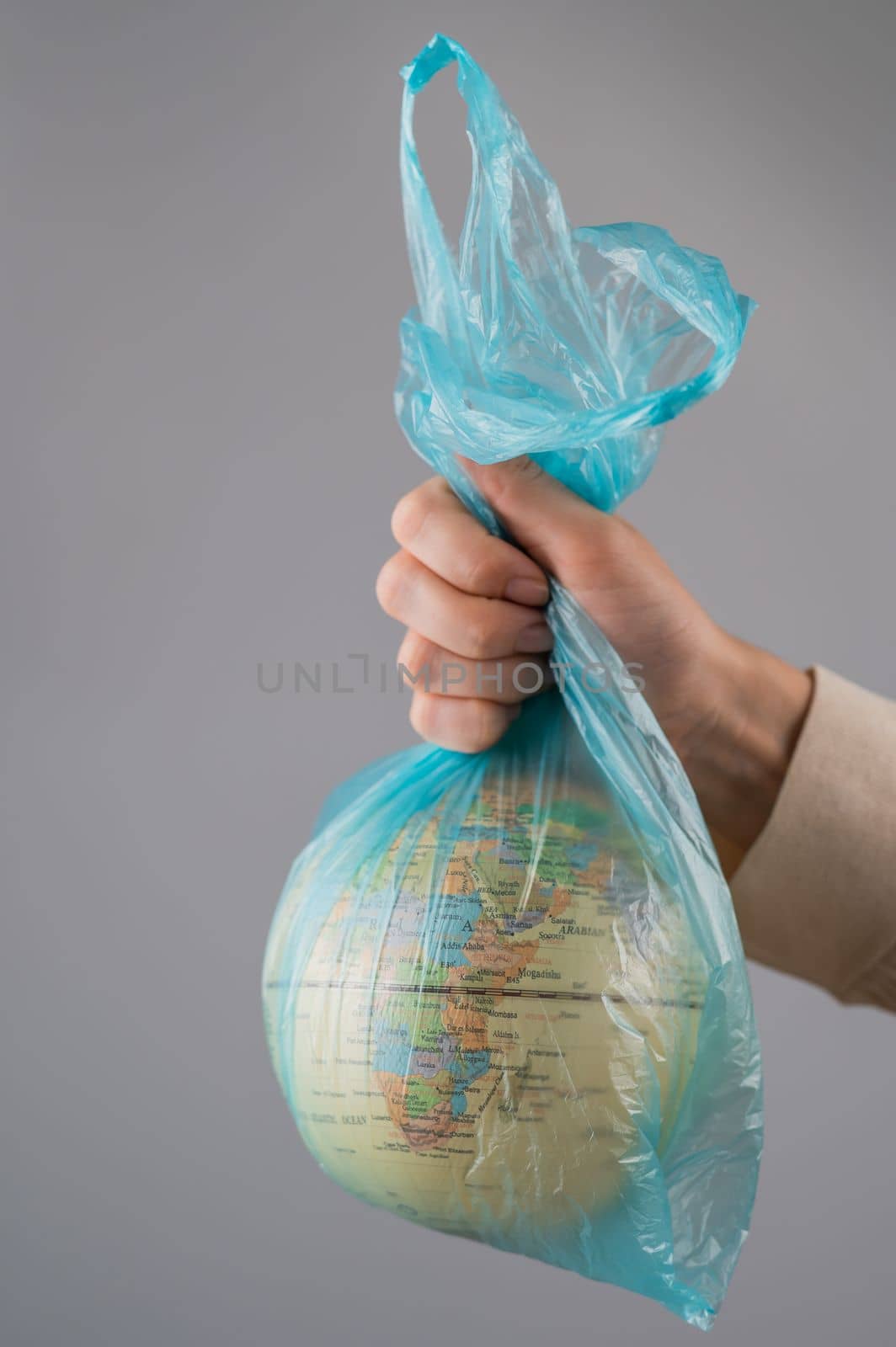 A woman is holding a globe in a plastic bag on a white background. by mrwed54