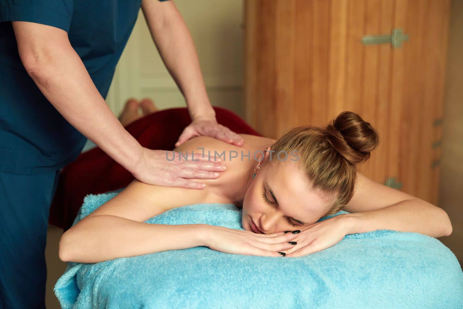 Young woman receiving massage in spa salon by Mariakray