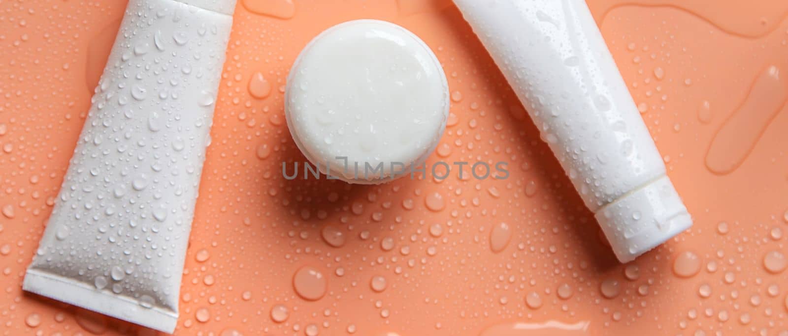 Moisturizing cosmetics on a wet background. Selective focus. by mila1784