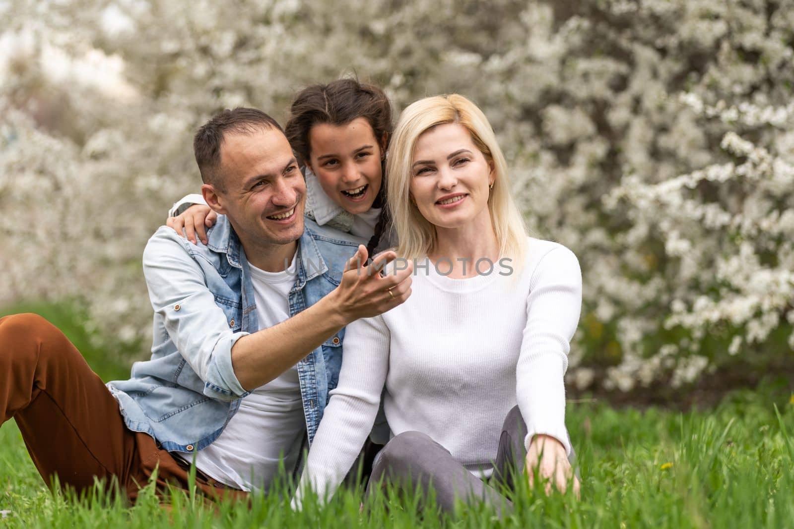Family and small child outdoors in spring nature, resting