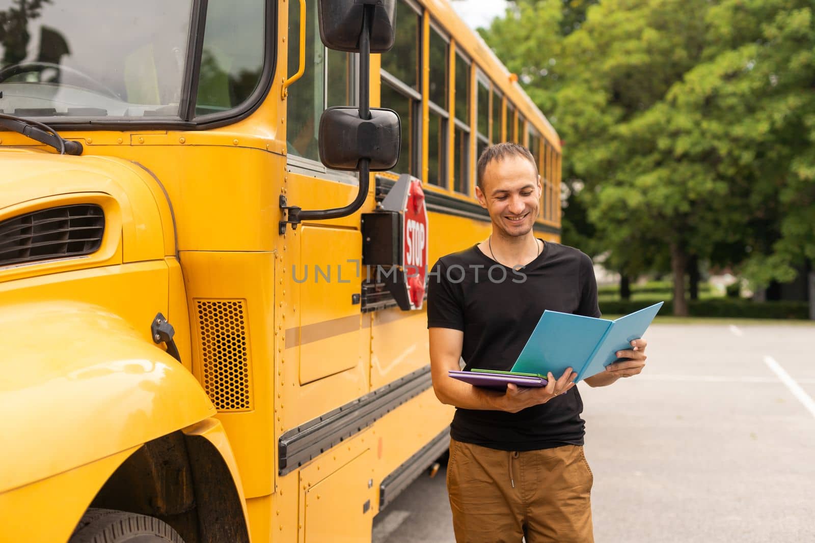 Portrait of male teacher near the school bus by Andelov13