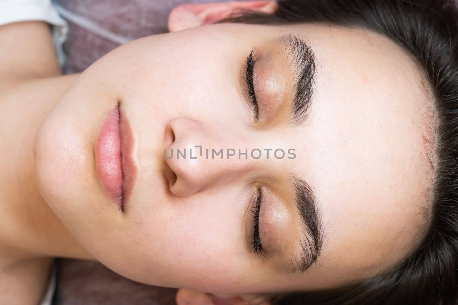 Woman lying on the couch after eyelash lamination procedure. by mrwed54