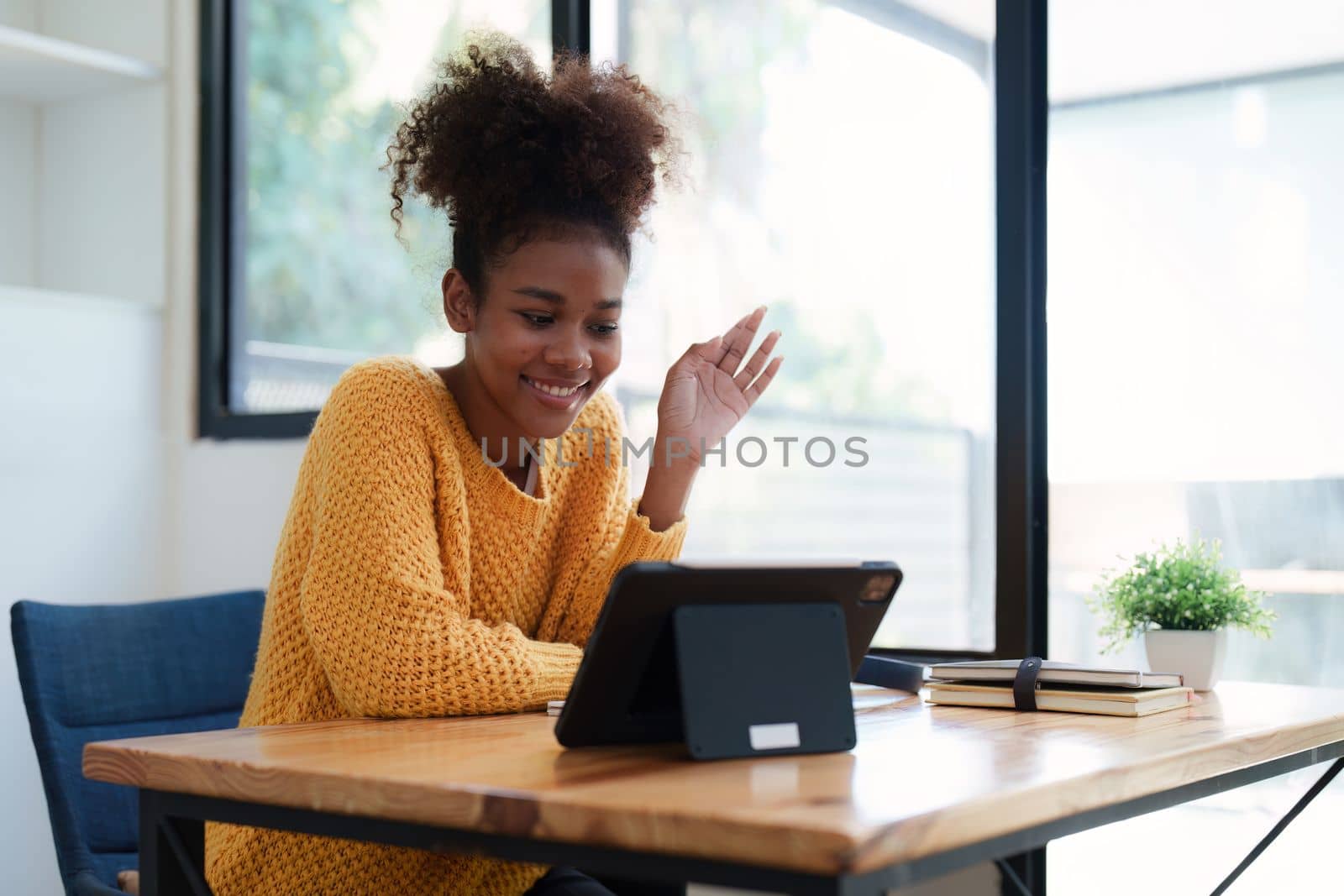 Young black curly hair american african woman using digital tablet.