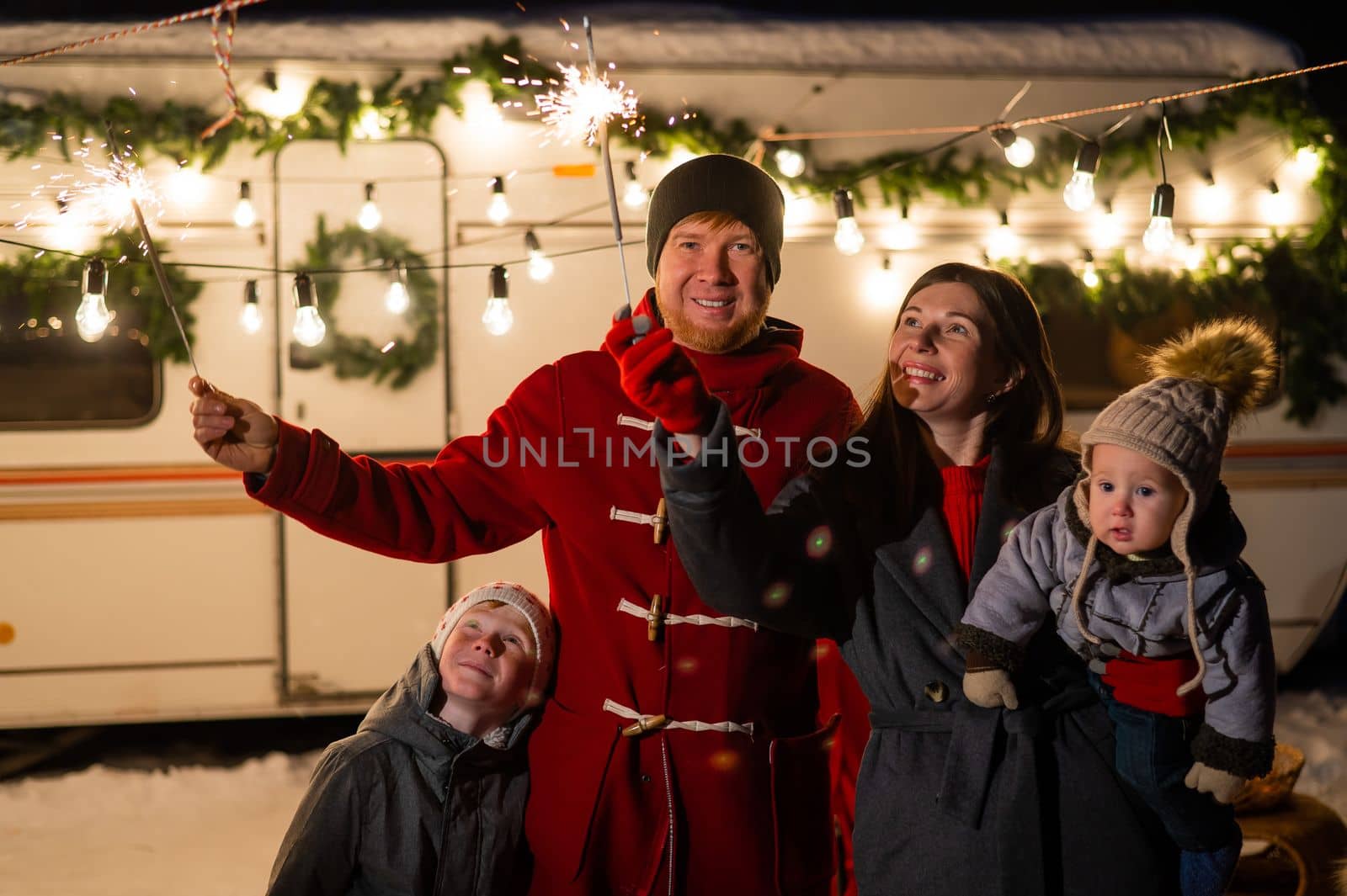 Happy parents with two sons celebrating christmas in motorhome. by mrwed54