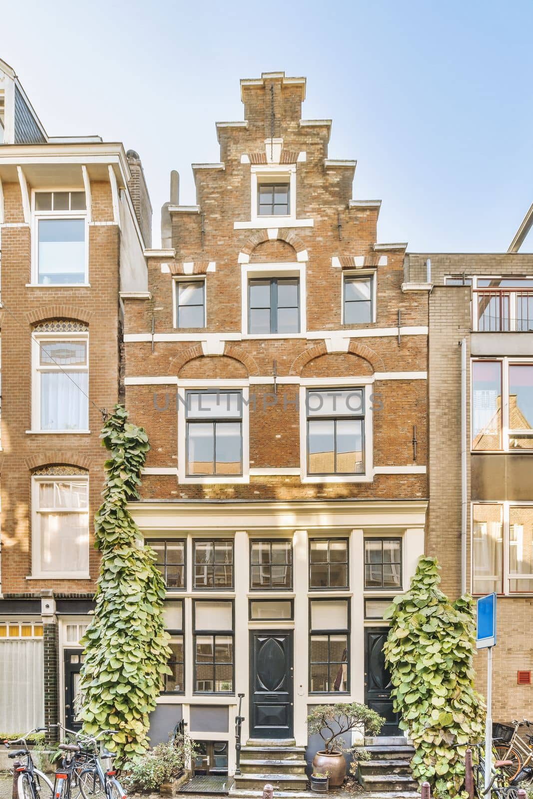 an apartment building with bicycles parked on the sidewalk in front of it and two people walking down the street next to them