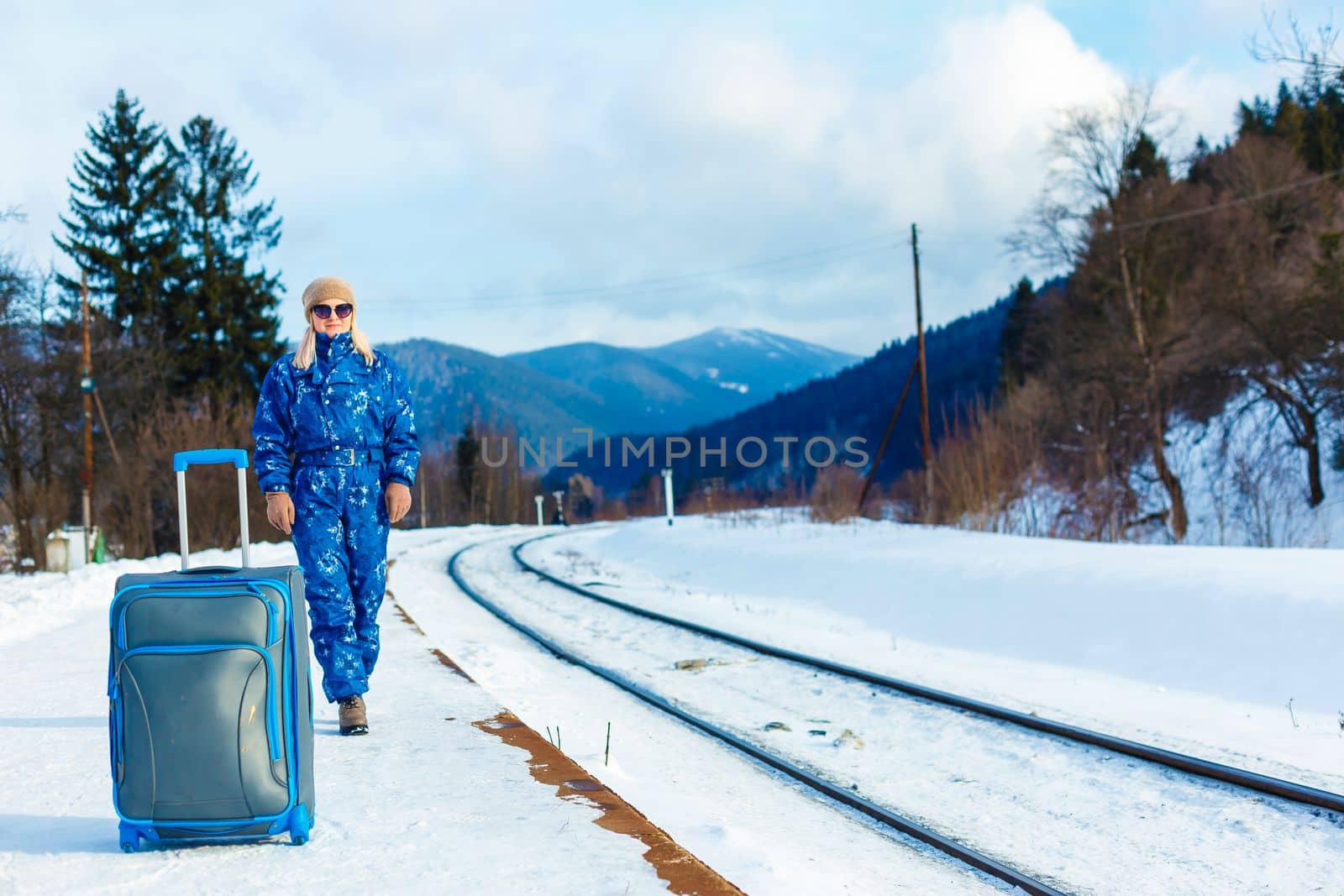 woman in ski suits stands near the railway