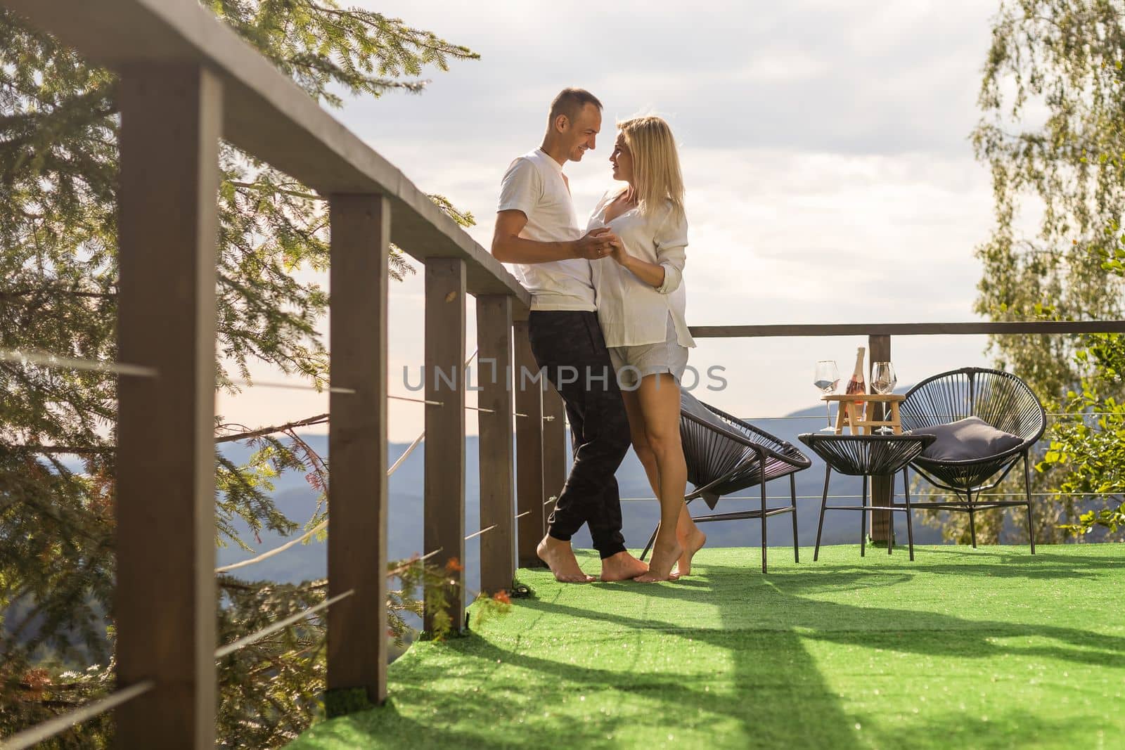 A man and a woman in tourist equipment are standing on a rock and admiring the panoramic view. A couple in love on a rock admires the beautiful views. A couple in love is traveling. A couple on a hike