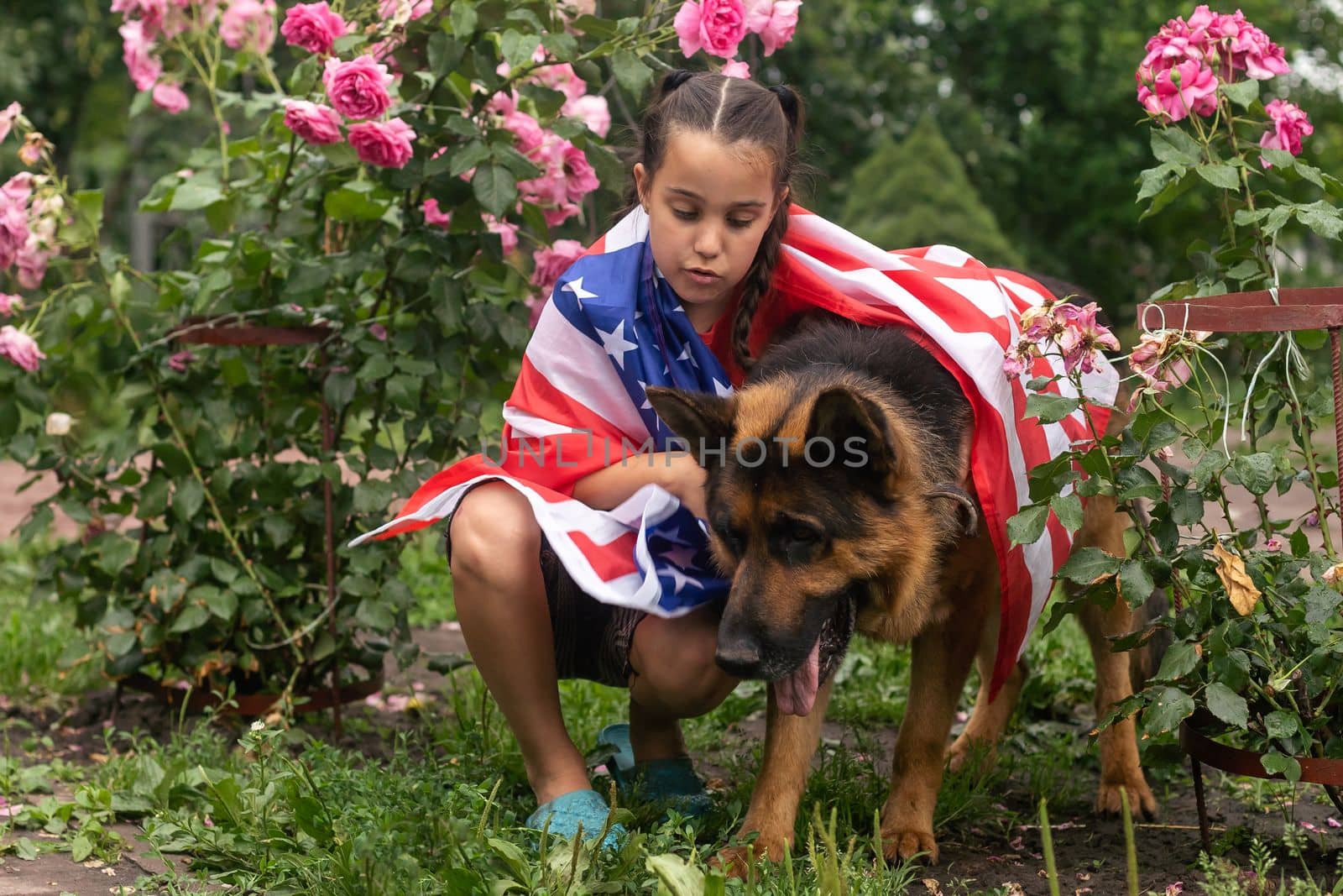 Happy little girl patriot running in the field with American flag. USA celebrate 4th of July. High quality photo