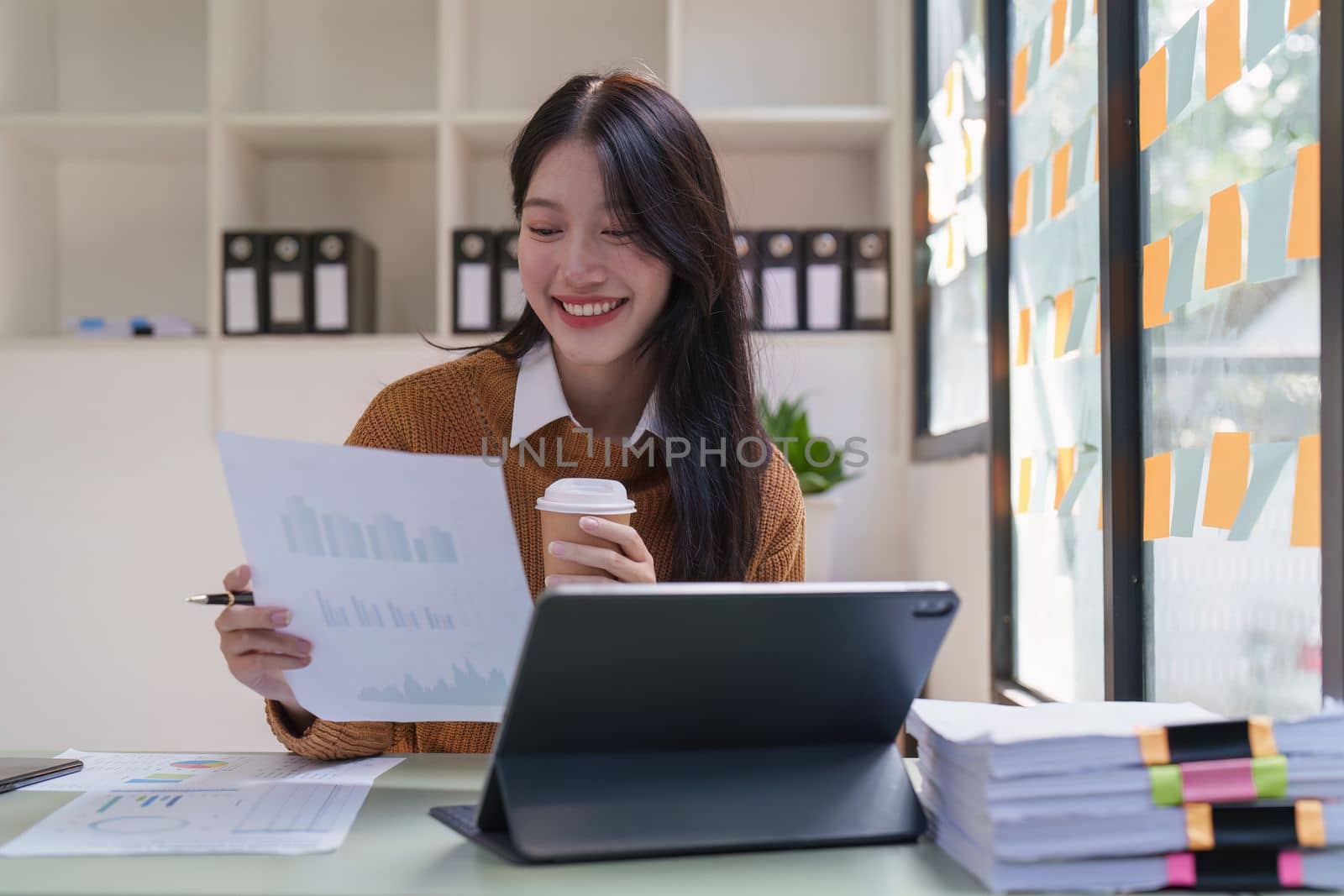 Asian Business woman working at home office and analyze financial report document. Accounting and Finance concept by itchaznong