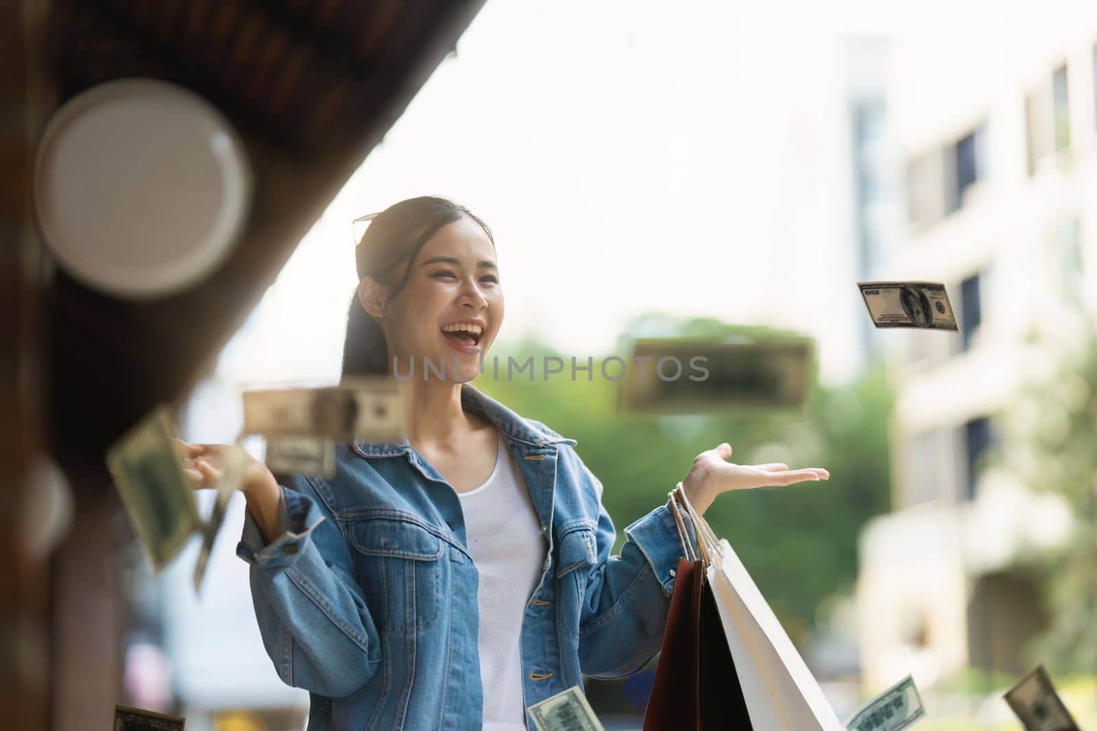 Asian fashionable woman walking at shopping mall with shopping bags while flash sale promotion.