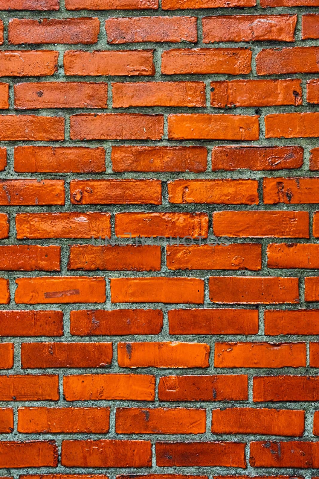 Image of Vertical vibrant orange brick wall straight on texture with dark gray mortar