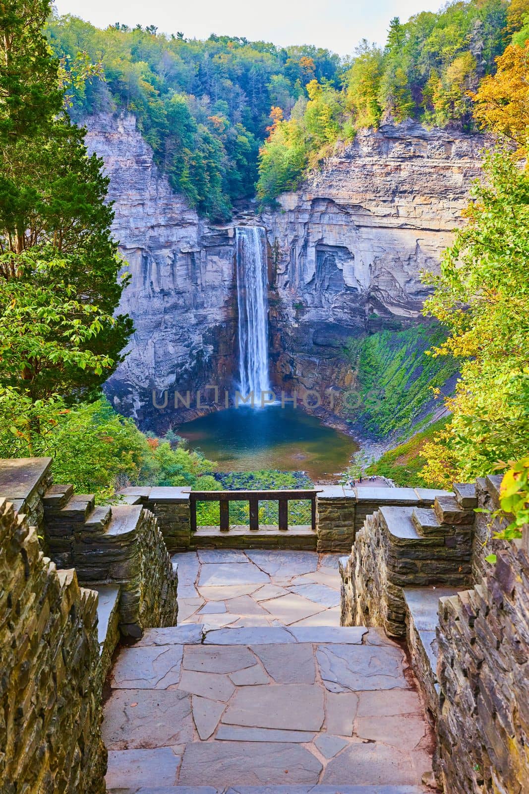 Image of Stone steps lead to overlook of huge waterfall into canyon surrounded by fall foliage