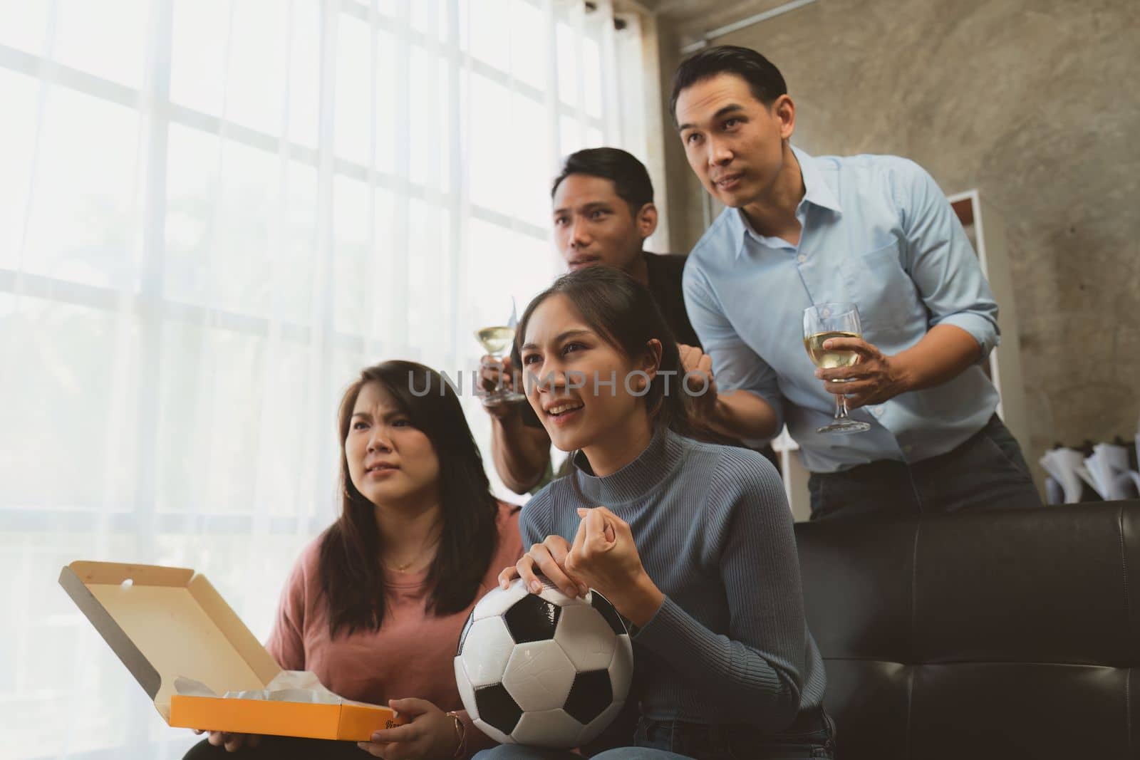 Excited friends having fun by watching football or soccer match and eating pizza at home. Friendship, leasure, rest, home party football, Soccer concept by itchaznong