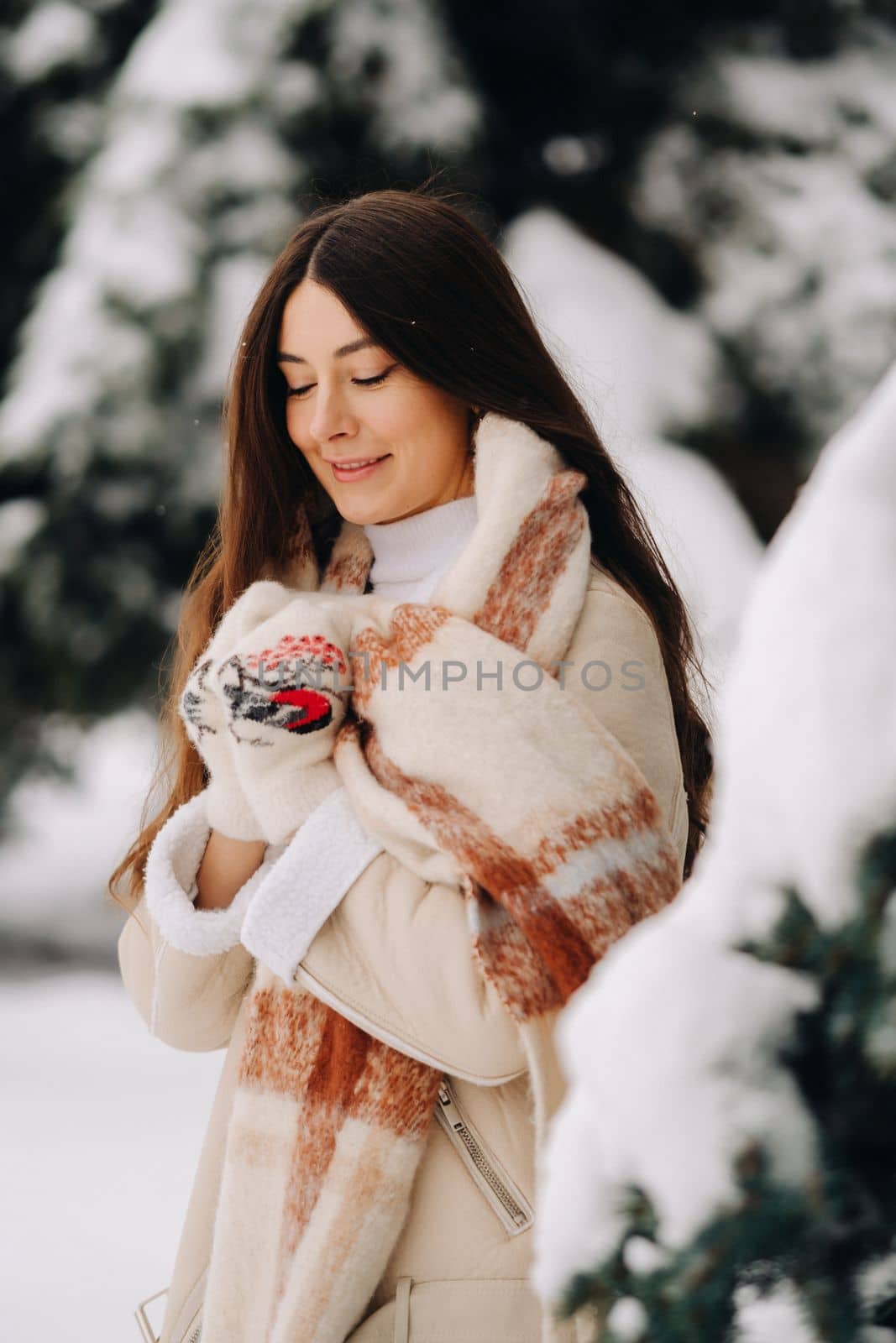 Portrait of a girl with long hair in mittens in a winter forest . Snowy winter by Lobachad