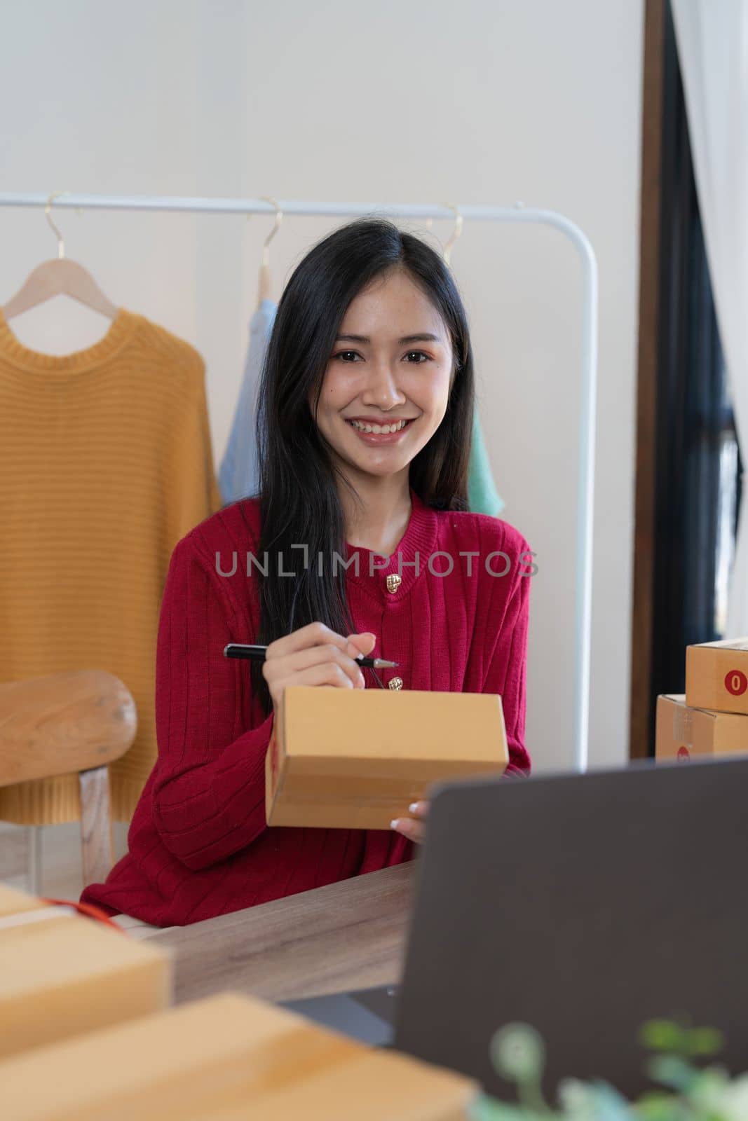 Startup small business entrepreneur of freelance Asian woman using a laptop with box Cheerful success online marketing packaging box and delivery SME idea concept.